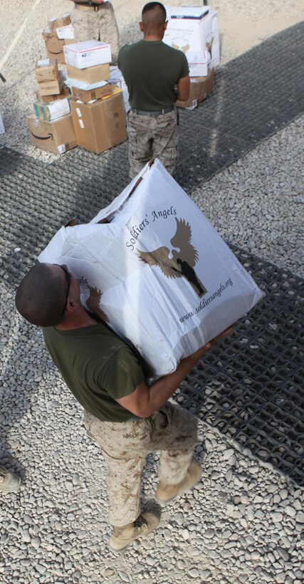 Lance Cpl. Peter Hager, a motor transport operator with Marine Air-Ground Task Force 11.2, 2nd Marine Logistics Group (Forward), carries a large donated package for a fellow Marine aboard Camp Leatherneck, Afghanistan, Oct. 9, 2011.  Anonymous care packages arrive for deployed servicemembers on a daily basis, bringing a morale boost for those stationed throughout Helmand province.