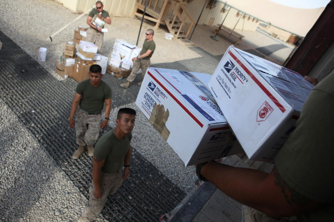 Marines with Marine Air-Ground Task Force Support Battalion 11.2, 2nd Marine Logistics Group (Forward), unload packages from a large truck during mail call aboard Camp Leatherneck, Afghanistan, Oct. 9, 2011.  It takes multiple Marines to collect, sort and deliver the letters and packages to the deployed servicemembers seven days a week.