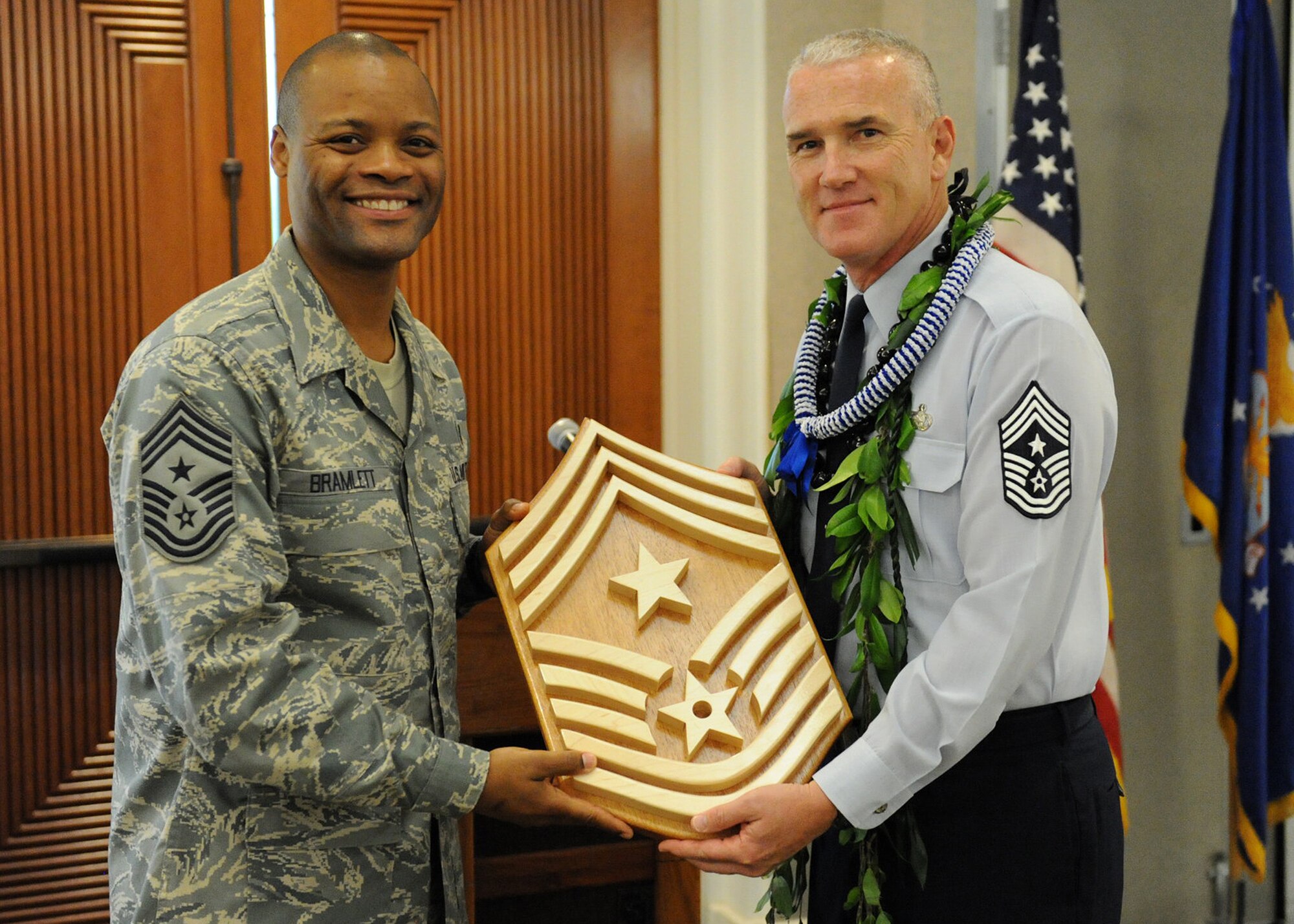 Chief Master Sgt. Leslie Bramlett, 15th Wing command chief presents Chief Master Sgt. Brooke McLean, PACAF command chief, with a command chief plaque during his retirement luncheon at the Enlisted Club, Joint Base Pearl Harbor-Hickam, Hawaii, on Nov. 16, 2012. Command Chiefs advise the commander on all the enlisted matters, including all issues affecting the commands’ mission and operations. (U.S. Air Force photo/Tech. Sgt. Jerome S. Tayborn/Released)