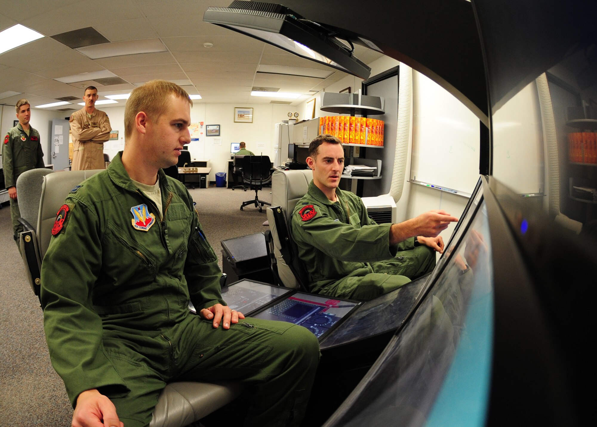 Two pilots use a flight simulator to become familiar with an Air Force MC-12W Liberty intelligence, surveillance, and reconnaissance aircraft at the 489th Reconnaissance Squadron Beale Air Force Base, Calif., Oct. 9, 2012. After training with the 489th RS, the pilots will become part of the operations unit associated with the MC-12W, the 427th RS. (U.S. Air Force photo by Senior Airman Shawn Nickel/Released)