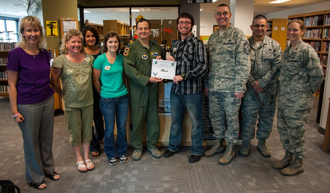 Derick Yara, 47th Force Support Squadron library technician, poses with Col. Mark Doria, 47th Flying Training Wing vice commander, and Chief Master Sergeant Garry Berry, 47th FTW command chief, after being presented the XLer of the Week award at Laughlin Air Force Base, Texas, Oct. 24, 2012. The XLer is a weekly award chosen by wing leadership and given to those who consistently make outstanding contributions to Laughlin and their unit. (U.S. Air Force photo/Airman 1st Class Nathan Maysonet)