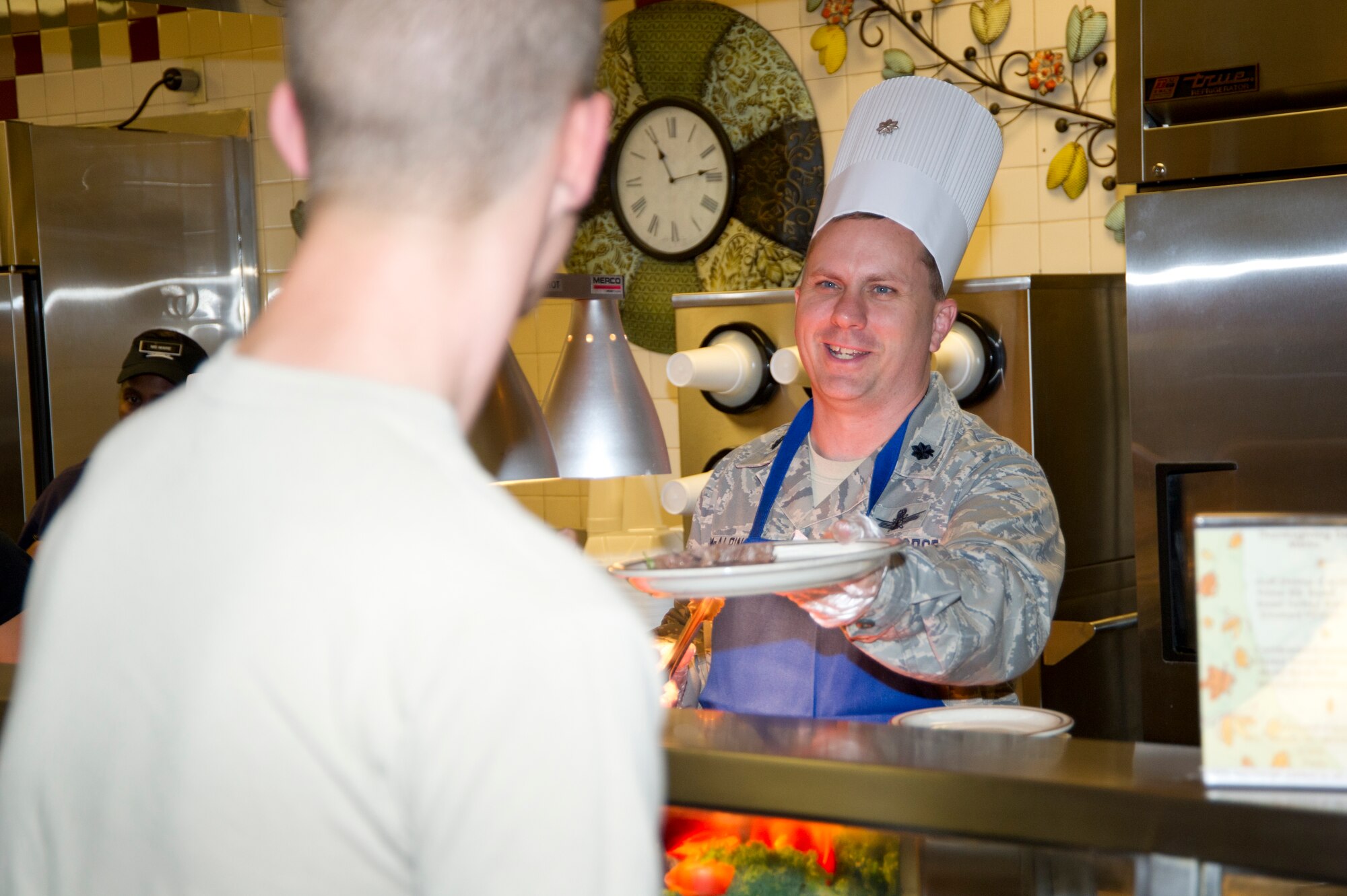 Lt. Col. Brad McAlpine, 335th Training Squadron commander, offers a serving of roast beef to Airman Basic Robert Castelberry, 334th Training Squadron, during Thanksgiving lunch Nov. 22, 2012, at the Azalea Dining Facility, Keesler Air Force Base, Miss.  It is traditional at Keesler for commanders, first sergeants and superintendents to take time out of their holiday to serve a Thanksgiving meal at the dining facilities to their Airmen.  (U.S. Air Force photo by Adam Bond)