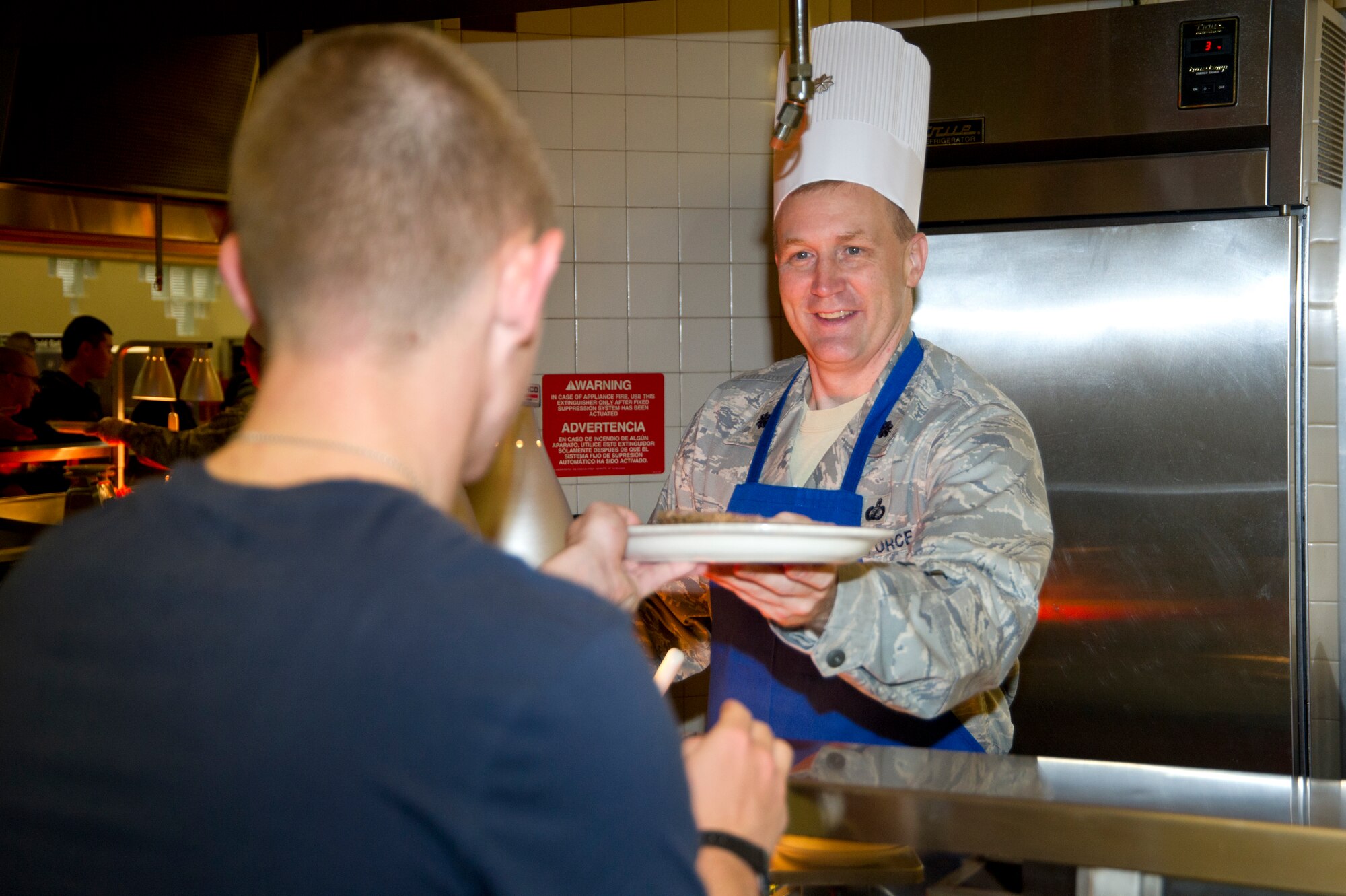 Lt. Col. Jonathan Wright, 81st Mission Support Group deputy commander, serves food to Airman Basic Kevin McKinnon, 335th Training Squadron, during Thanksgiving lunch Nov. 22, 2012, at the Azalea Dining Facility, Keesler Air Force Base, Miss. It is traditional at Keesler for commanders, first sergeants and superintendents to take time out of their holiday to serve a Thanksgiving meal at the dining facilities to their Airmen.  (U.S. Air Force photo by Adam Bond)