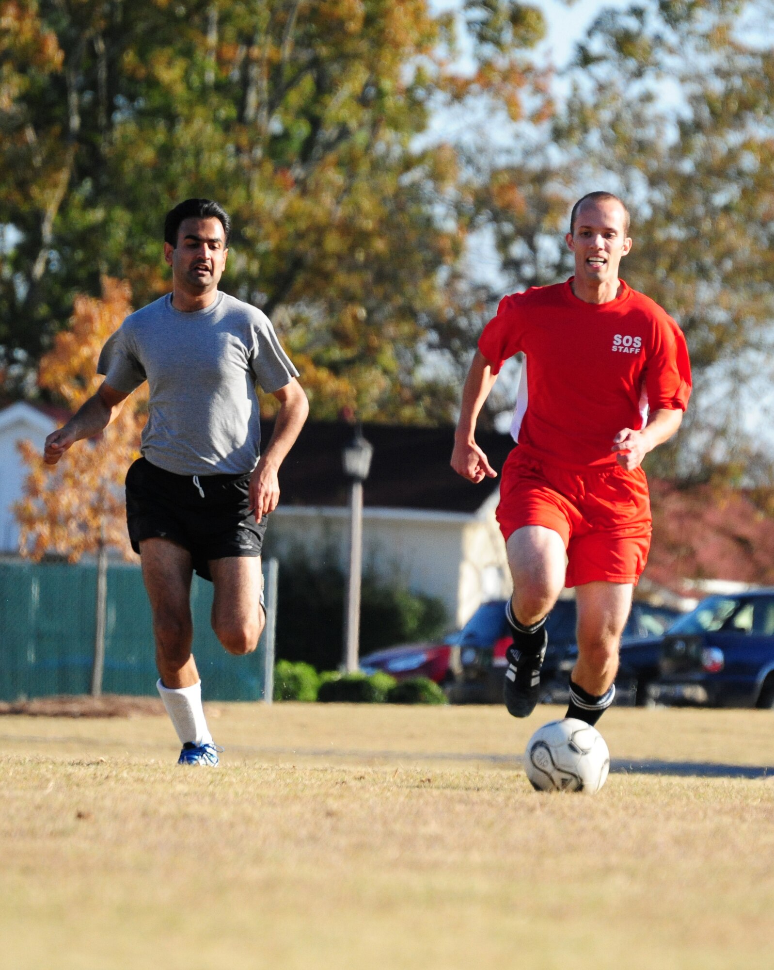 Squadron Officer School instructor Brent Hassler drives the ball downfield as International School Student Husam Al Nadhairi chases during a friendly match of soccer on Nov. 16. In the end, IOS proved too much for SOS as they won with a score of 6-2. (U.S. Air Force photo by Senior Airman Christopher Stoltz)