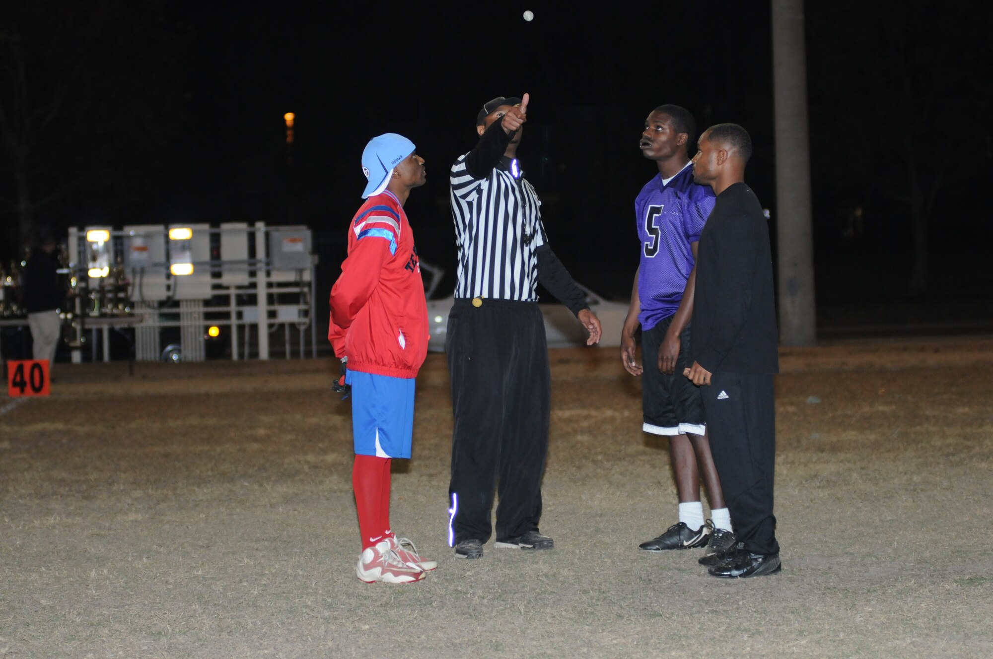 Trae Clark, 334th Training Squadron; Denzel Satterfield and Rodney Watson, 403rd Wing, watch closely as referee, Terrell Sutton, flips a coin to decide which team will start with the ball during the intramural flag football championship game Nov. 26, 2012, Keesler Air Force Base, Miss.  The 334th TRS defeated the 403rd, 28-26.  (U.S. Air Force photo by Kemberly Groue)