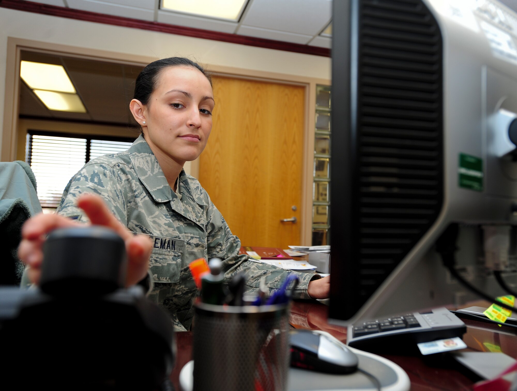 Senior Airman Shalamar Coleman, 22nd Air Refueling Wing knowledge operations manager, reaches for a phone call Nov. 26, 2012, McConnell Air Force Base, Kan. Coleman was selected as the spotlight performer for the week of Nov. 19 to 23 due to her dedication to the commander’s intents. (U.S. Air Force photo/Senior Airman Armando A. Schwier-Morales) 