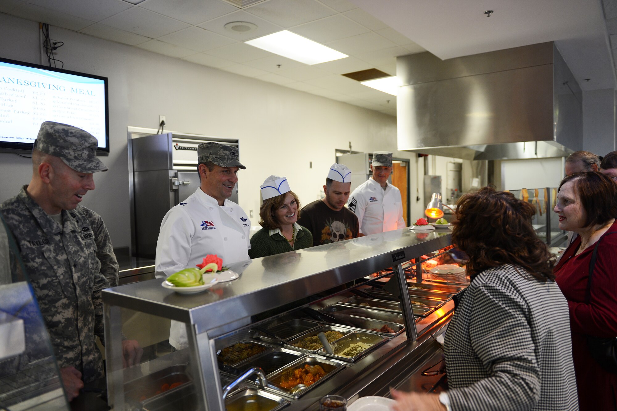 Team Shaw leadership gladly serves Team Shaw members Thanksgiving lunch as they make their way through the line at Shaw Air Force Base, S.C., Nov. 23. The dining facility offered many Thanksgiving options from turkey, stuffing, corn and peas to cake, pie and other pastries. (U.S. Air Force photo by Airman 1st Class Daniel Blackwell/Released)