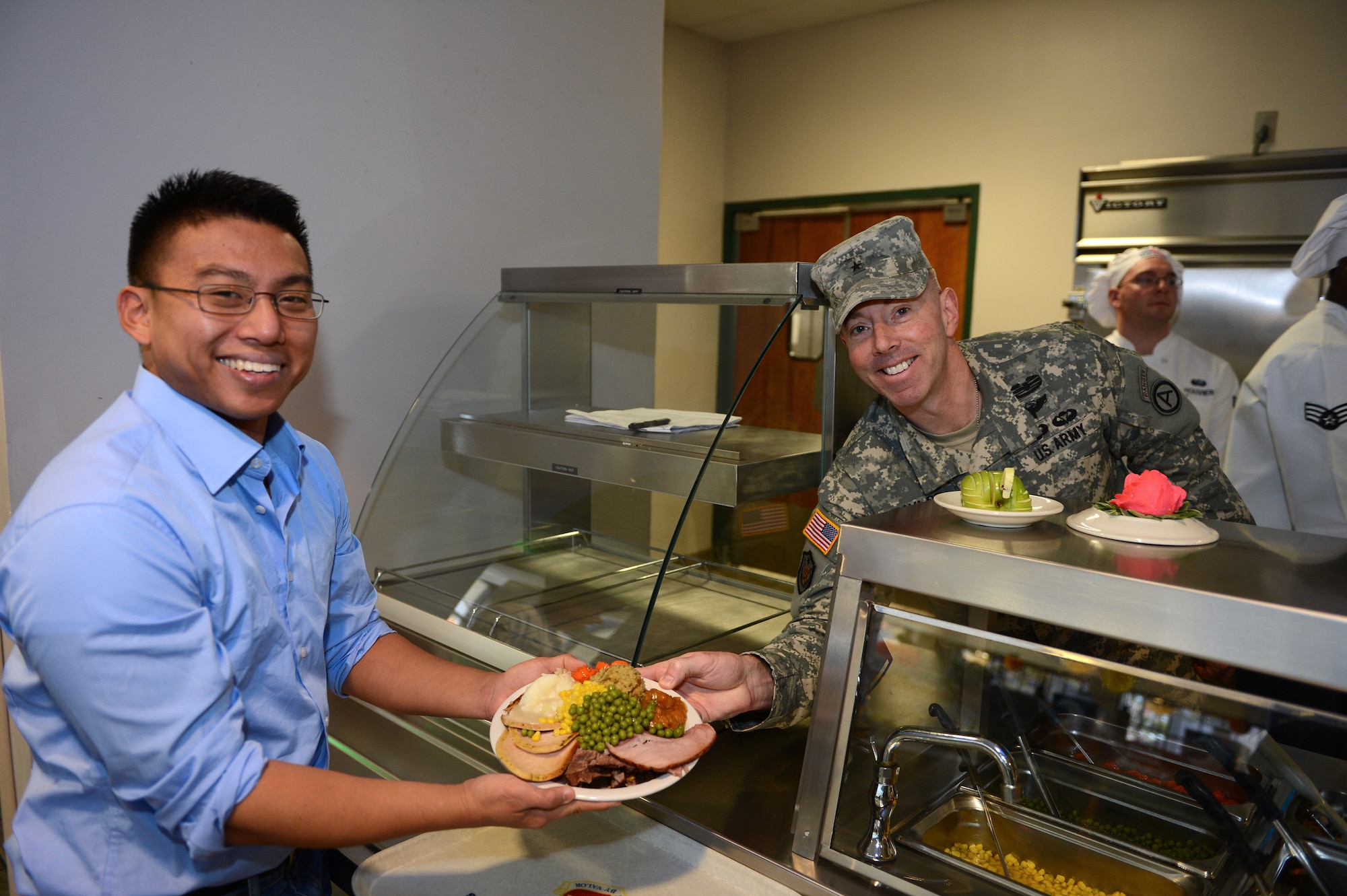 Brig. Gen. Chuck Taylor, Third Army chief of staff, poses with a Team Shaw member as he serves him Thanksgiving lunch, Shaw Air Force Base, S.C., Nov. 23, 2012. Team Shaw leadership served lunch at the dining facility to help celebrate Thanksgiving Day. (U.S. Air Force photo by Airman 1st Class Daniel Blackwell/Released)