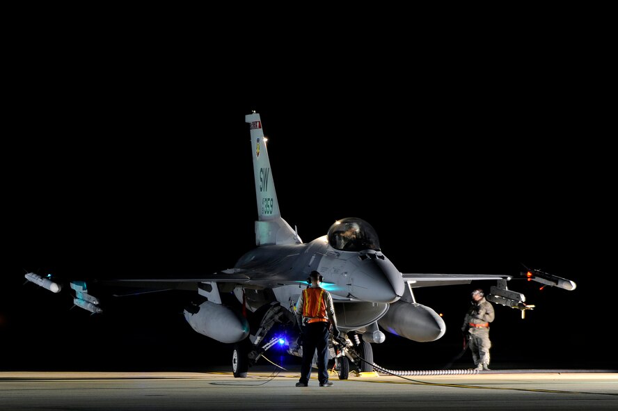 Darkness wraps around two crew chiefs and a U.S. Air Force F-16 Fighting Falcon pilot as a technique called hot pit refueling is performed, Nov. 9, 2012, Shaw Air Force Base, S.C. Hot pit refueling is a procedure usually performed in a combat situation to rapidly refuel aircraft while their engines are running resulting in a speedy refuel to thrust pilots right back into the fight. Airmen assigned to the 20th Logistics Readiness Squadron and 20th Aircraft Maintenance Squadron practice this technique to keep their skills sharp and aid in the effort to provide combat ready air power at a moment’s notice. (U.S. Air Force photo by Staff Sgt. Kenny Holston/Released)