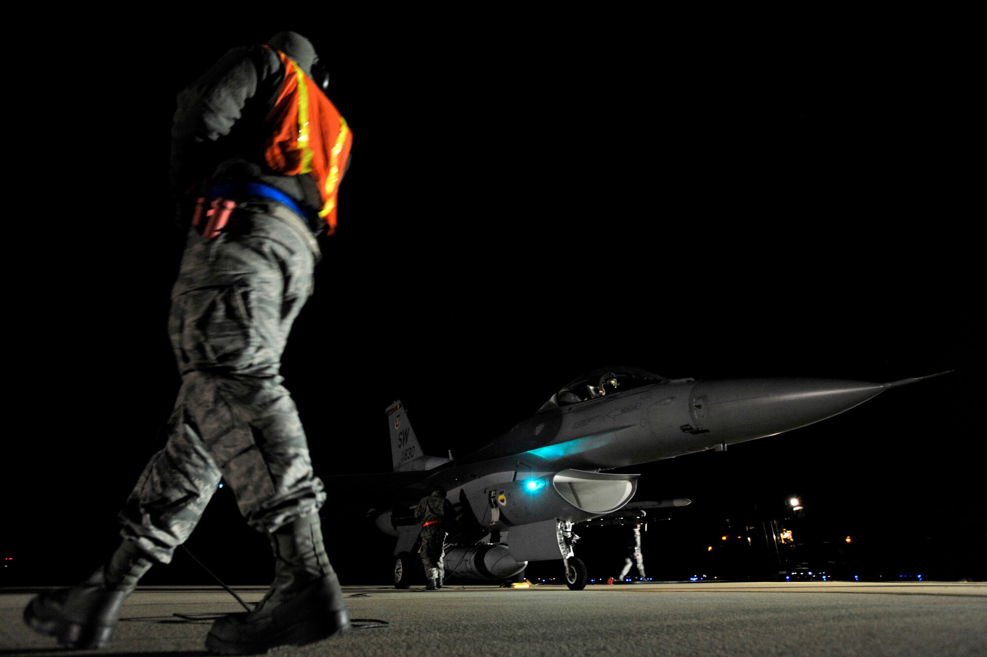 U.S. Air Force Senior Airman Aaron Simonson, 20th Aircraft Maintenance Squadron crew chief, (left) walks around an F-16 Fighting Falcon as he communicates with the pilot of the aircraft during a hot pit refuel, Nov. 8, 2012, Shaw Air Force Base, S.C. Hot pit refueling is a procedure usually performed in a combat situation to rapidly refuel aircraft while their engines are running, resulting in a speedy refuel to thrust pilots right back into the fight. Refueling specialists, crew chiefs and pilots assigned to the 20th Fighter Wing practice this procedure to keep their skills sharp and aid in the effort to provide combat-ready air power at a moment’s notice. (U.S. Air Force photo by Staff Sgt. Kenny Holston/Released)