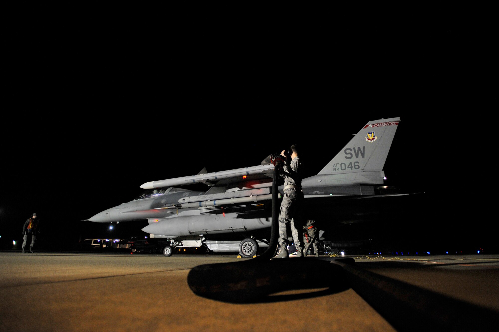 U.S. Air Force Staff Sgt. Milton Taylor, 20th Logistics Readiness Squadron fuels operator, pulls a fuel hose toward an F-16 Fighting Falcon aircraft while performing a hot pit refuel, Nov. 8, 2012, Shaw Air Force Base, S.C. Hot pit refueling is a procedure usually performed in a combat situation to rapidly refuel aircraft while their engines are running, resulting in a speedy refuel to thrust pilots right back into the fight. Airmen assigned to the 20th LRS and 20th Aircraft Maintenance Squadron practice this technique to keep their skills sharp and aid in the effort to provide combat-ready air power at a moment’s notice. (U.S. Air Force photo by Staff Sgt. Kenny Holston/Released)