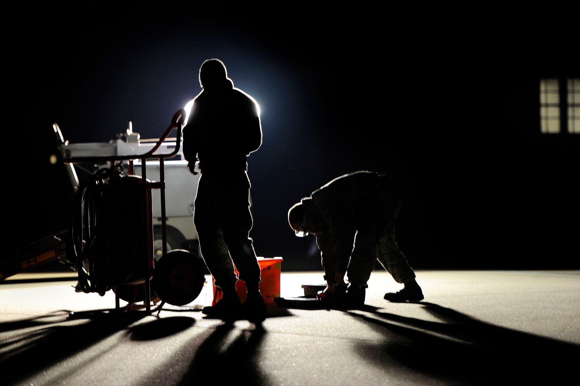 U.S. Air Force Senior Airman Aaron Simonson (left) and Senior Airman Jason Trexler, both crew chiefs assigned to the 20th Aircraft Maintenance Squadron, police their gear while performing hot pit refueling for F-16 Fighting Falcon pilots, Nov. 8, 2012, Shaw Air Force Base, S.C. Hot pit refueling is a procedure usually performed in a combat situation to rapidly refuel aircraft while their engines are running, resulting in a speedy refuel to thrust pilots right back into the fight. Refueling specialists, crew chiefs and pilots assigned to the 20th Fighter Wing practice this procedure to keep their skills sharp and aid in the effort to provide combat-ready air power at a moment’s notice. (U.S. Air Force photo by Staff Sgt. Kenny Holston/Released)