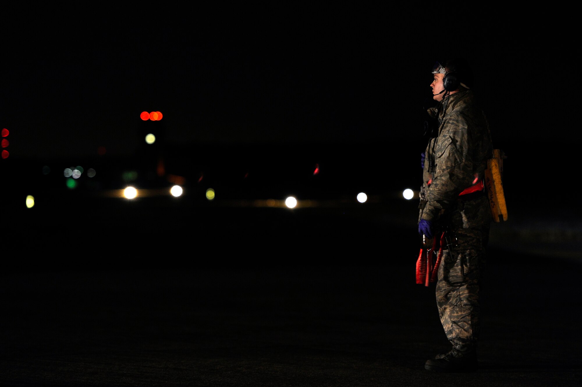 U.S. Air Force Senior Airman Jason Trexler, 20th Aircraft Maintenance Squadron crew chief, stands on the Shaw flightline holding chocks and other gear as he waits for the next F-16 Fighting Falcon aircraft to approach the hot pit for refueling, Nov. 8, 2012, Shaw Air Force Base, S.C. Hot pit refueling is a procedure usually performed in a combat situation to rapidly refuel aircraft while their engines are running, resulting in a speedy refuel to thrust pilots right back into the fight. Refueling specialists, crew chiefs and pilots assigned to the 20th Fighter Wing practice this procedure to keep their skills sharp and aid in the effort to provide combat-ready air power at a moment’s notice. (U.S. Air Force photo by Staff Sgt. Kenny Holston/Released)