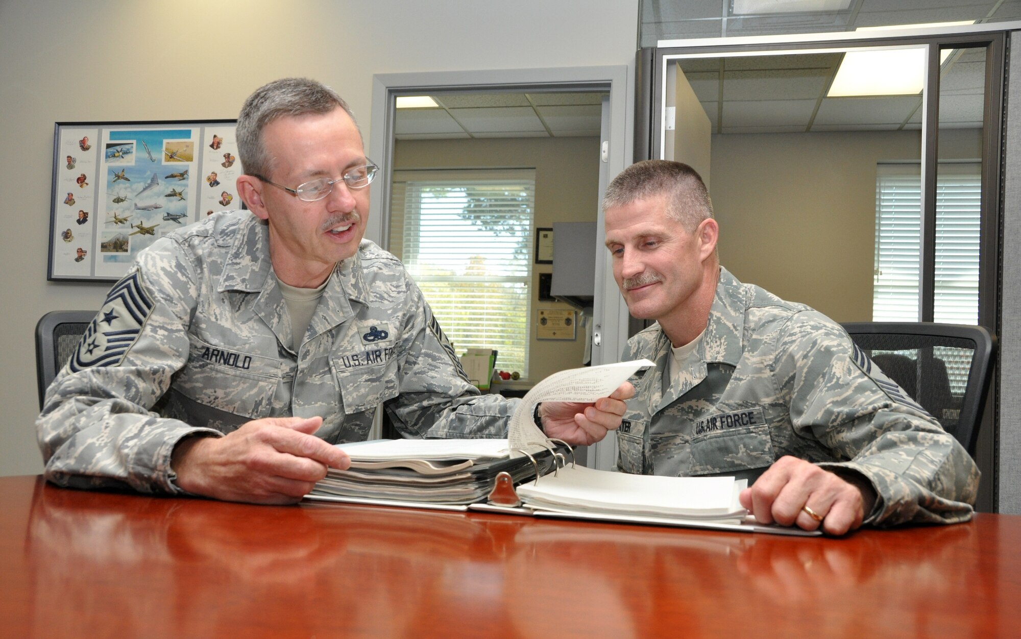 Command Chief Master Sgt. Steven Arnold, left, reviews policies with Command Chief Master Sgt. Asa Carter. Chief Carter was recently announced as Chief Arnold’s successor as Arkansas Air National Guard state command chief master sergeant. Chief Carter was previously the 188th Fighter Wing’s command chief master sergeant. (National Guard photo by Lt. Col. Keith Moore/Arkansas National Guard Public Affairs)