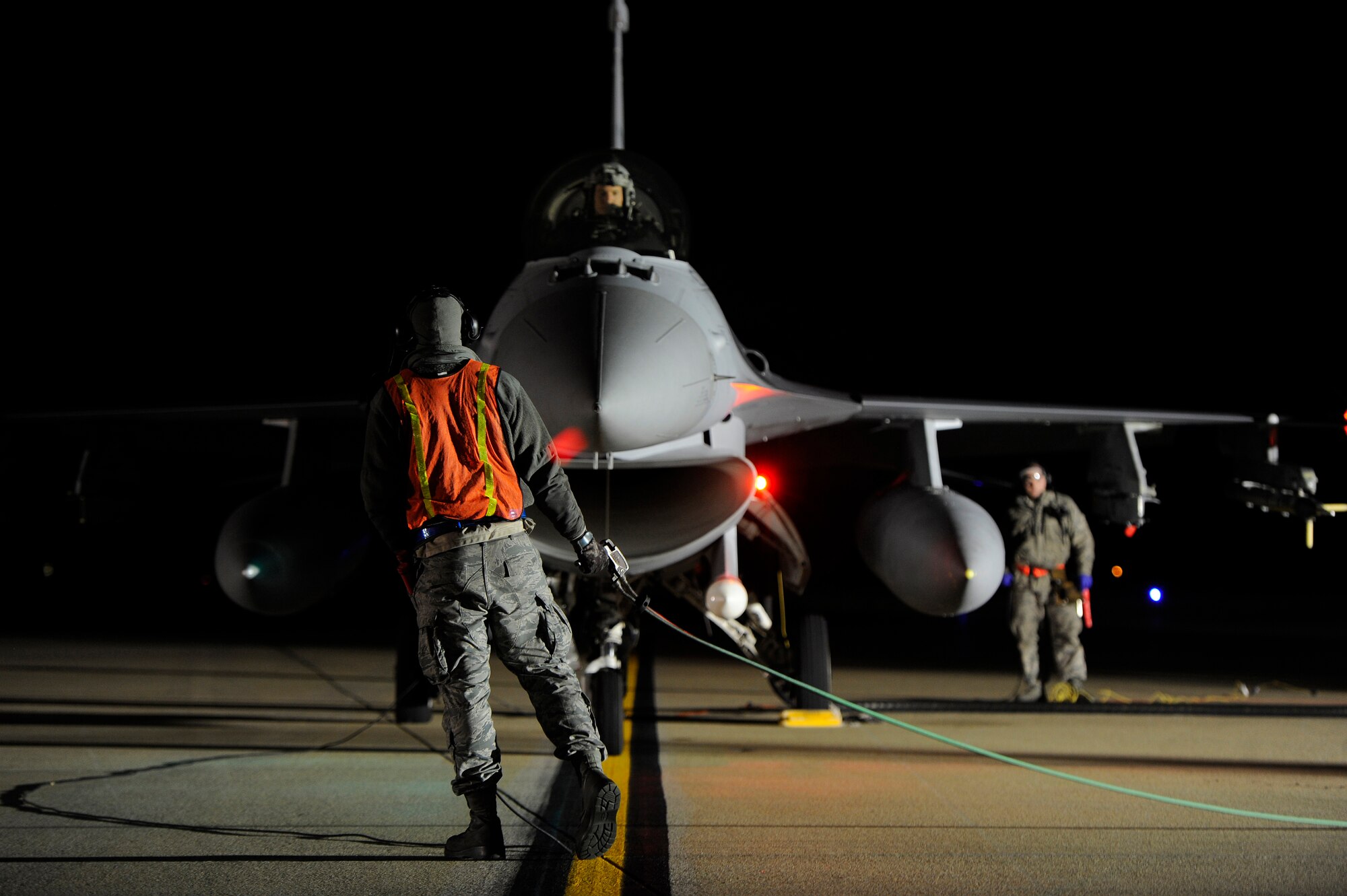 U.S. Air Force Senior Airman Aaron Simonson (center) and Senior Airman Jason Trexler, crew chiefs assigned to the 20th Aircraft Maintenance Squadron, communicate with 1st Lt. Josh Reddis, F-16 Fighting Falcon pilot, as he taxis in for a hot pit refuel, Nov. 8, 2012, Shaw Air Force Base, S.C. Hot pit refueling is a procedure usually performed in a combat situation to rapidly refuel aircraft while their engines are running, resulting in a speedy refuel to thrust pilots back into the fight. Refueling specialists, crew chiefs and pilots assigned to the 20th Fighter Wing practice this procedure to keep their skills sharp and aid in the effort to provide combat-ready air power at a moment’s notice. (U.S. Air Force photo by Staff Sgt. Kenny Holston/Released)