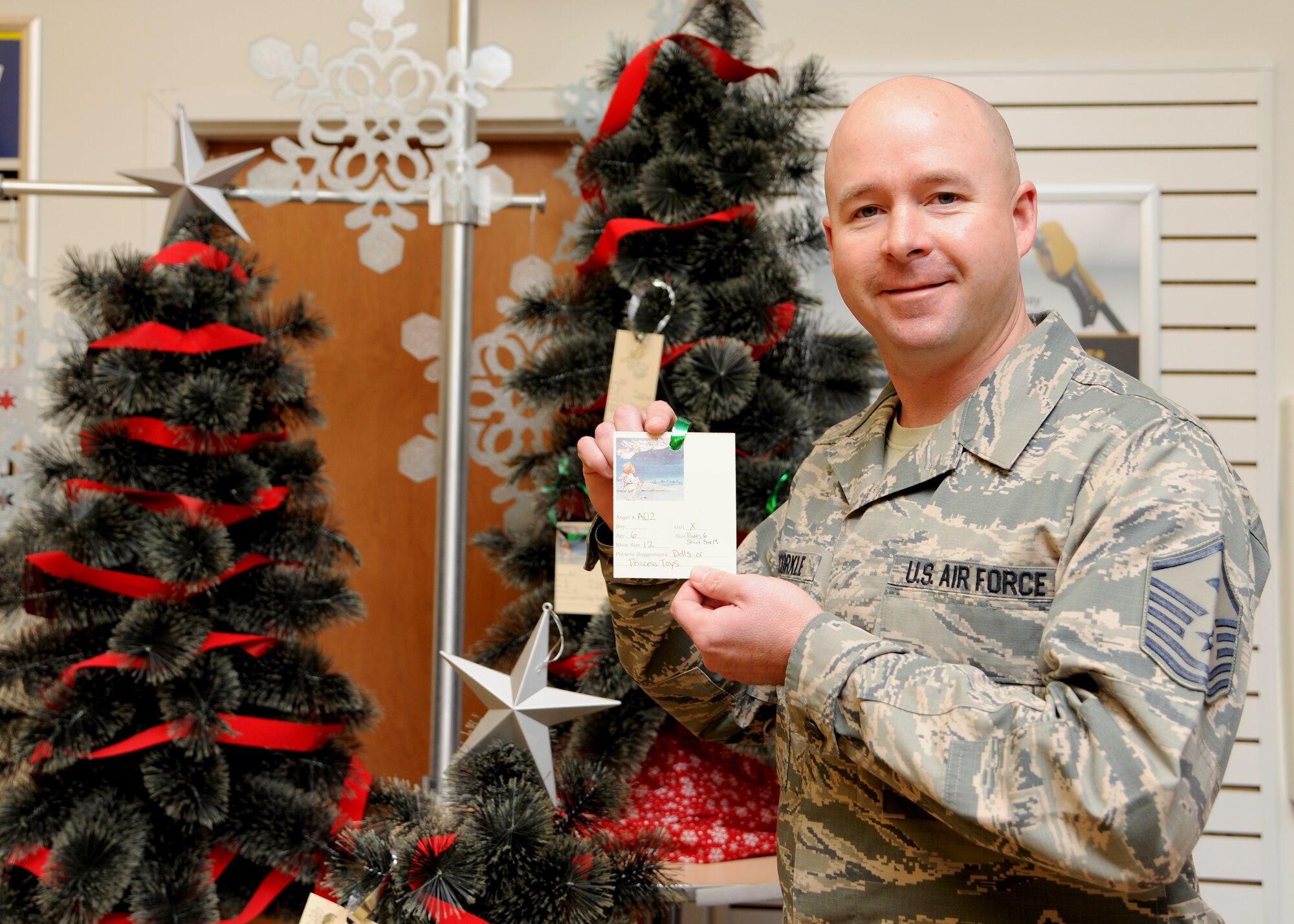 Master Sgt. Richard McCorkle, 319th Operations Support Squadron first sergeant, displays an “Angel Card” for the Angel Tree on Nov. 21, 2012, at the Base Exchange on Grand Forks Air Force Base, N. D. With around 70 names provided, the purpose of the Angel Tree is to ensure every child on GFAFB has a gift to open this holiday season.  Contact your first sergeant for details or to nominate an individual or family. (U.S. Air Force photo/Airman 1st Class Ashley N. Taylor)