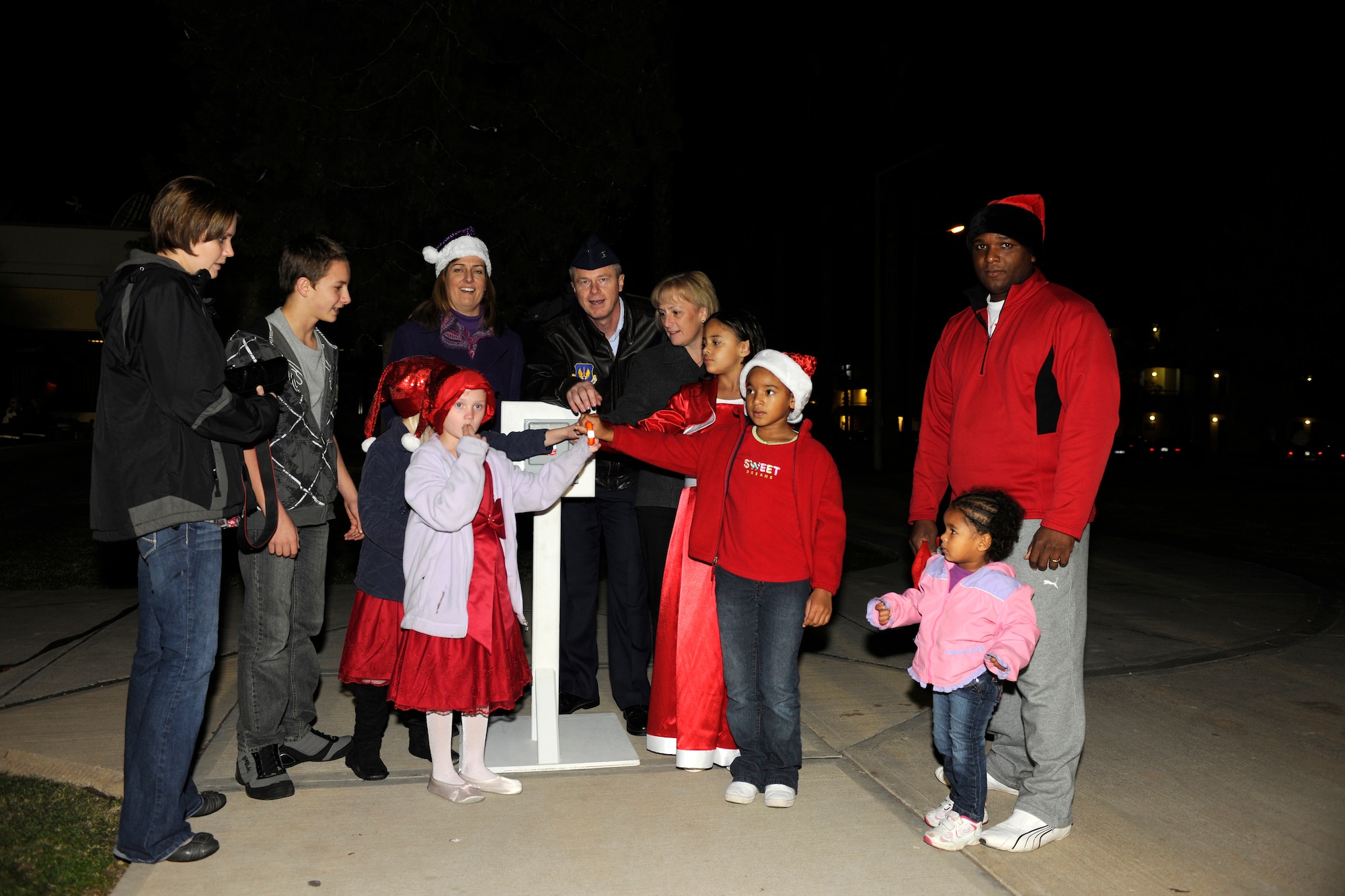 Incirlik members including Col. Brent Bigger, 39th Air Base Wing vice commander, his wife Carla and Penny Craige, the wing commander’s wife, flip the switch to light the holiday tree outside the club complex during the base tree lighting ceremony Nov. 26, 2012, at Incirlik Air Base, Turkey. A children’s choir from the Incirlik Unit School performed, Santa Claus arrived on a fire truck, and free snacks were given during the event. (U.S. Air Force photo by Tech. Sgt. Dallas Edwards/Released)