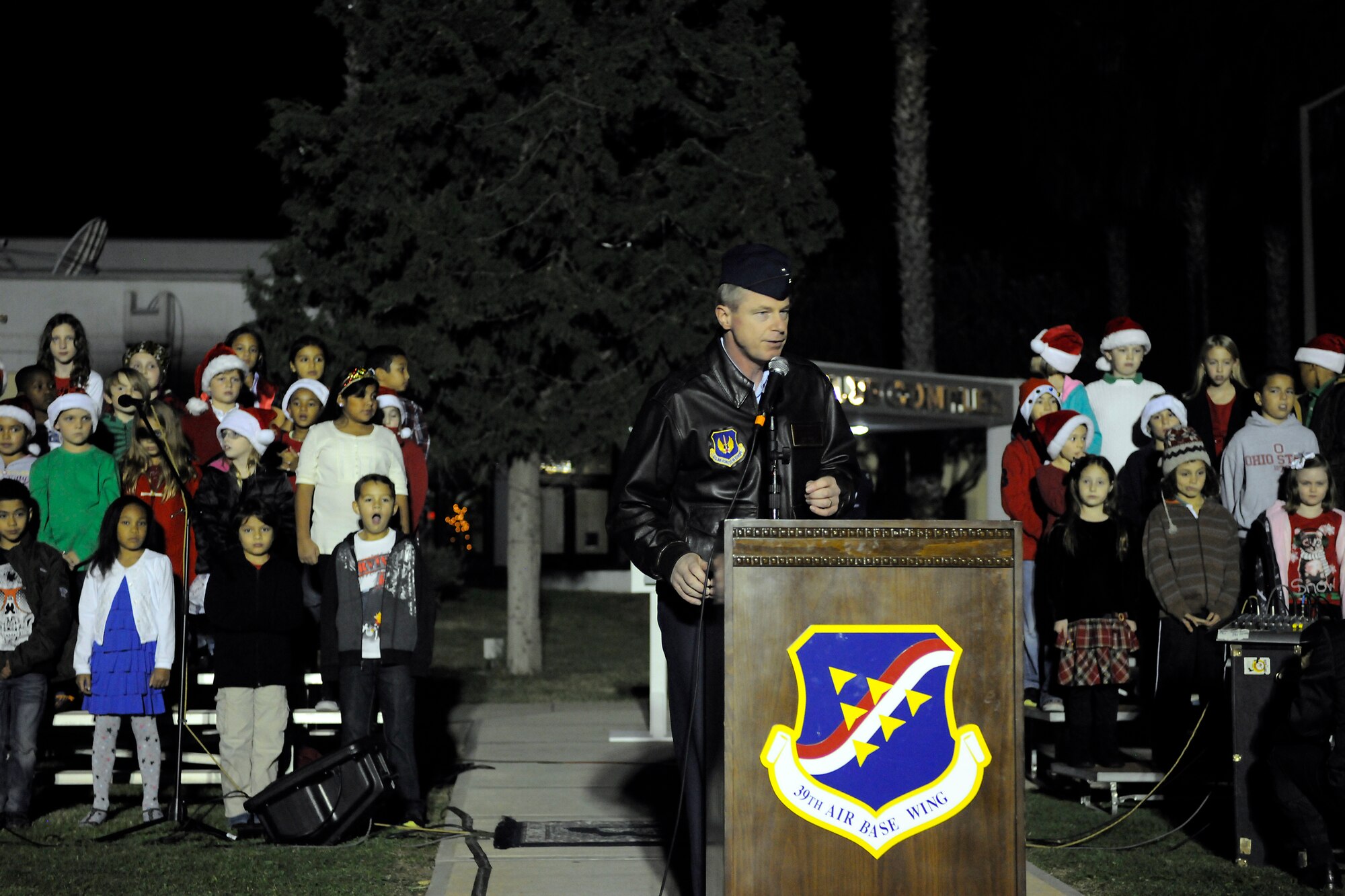 Col. Brent Bigger, 39th Air Base Wing vice commander, speaks to a crowd gathered outside the club complex during the base tree lighting ceremony Nov. 26, 2012, at Incirlik Air Base, Turkey. A children’s choir from the Incirlik Unit School performed, and Santa Claus arrived on a fire truck during the event. (U.S. Air Force photo by Tech. Sgt. Dallas Edwards/Released)
