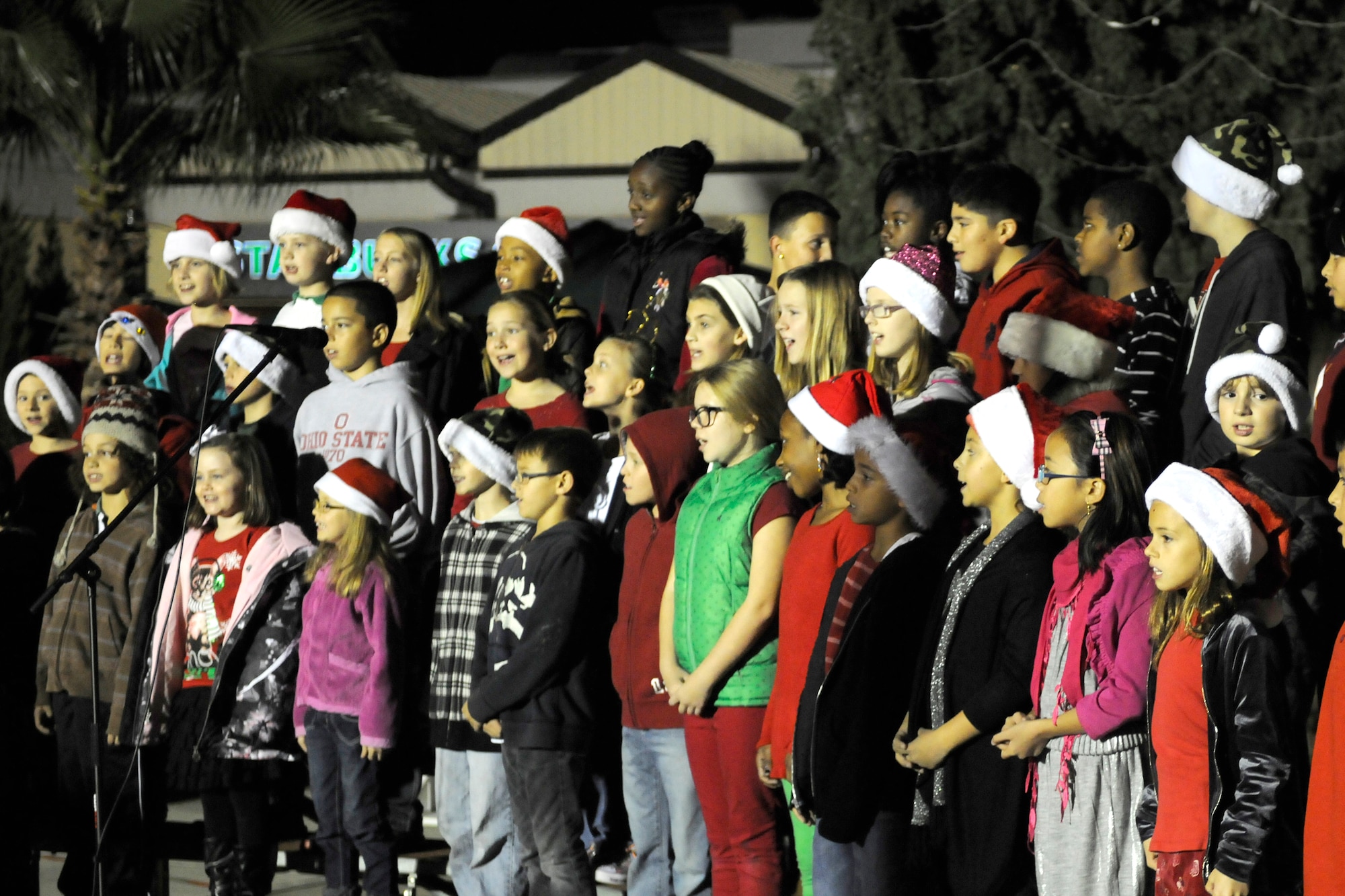 A children’s choir from the Incirlik Unit School performs outside the  club complex during the base tree lighting ceremony Nov. 26, 2012, at Incirlik Air Base, Turkey. The ceremony included a tree lighting and a visit from Santa Claus. (U.S. Air Force photo by Tech. Sgt. Dallas Edwards/Released)