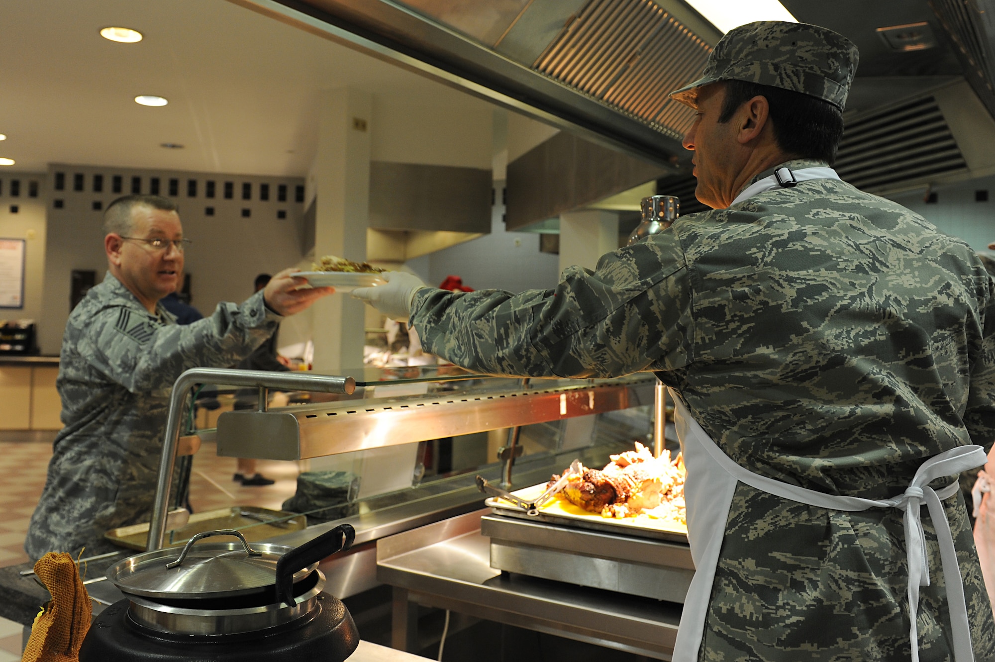 Lt. Gen. Noel T. Jones, U.S. Air Forces in Europe and Air Forces Africa vice
commander, carves turkey for Chief Master Sgt. Michael Dilt, U.S.
Air Forces in Europe and Air Forces Africa Directorate of Manpower,
Personnel, and Services chief enlisted manager/3SO major command functional
manager, on Thanksgiving Day at the Rheinland Inn Dining Facility on
Ramstein Air Base, Germany, Nov. 22, 2012. The dining facility along with
many base leadership volunteers and their families served up a taste of home
for KMC Airmen and their families. (U.S. Air Force photo/Airmen 1st Class
Holly Cook)
