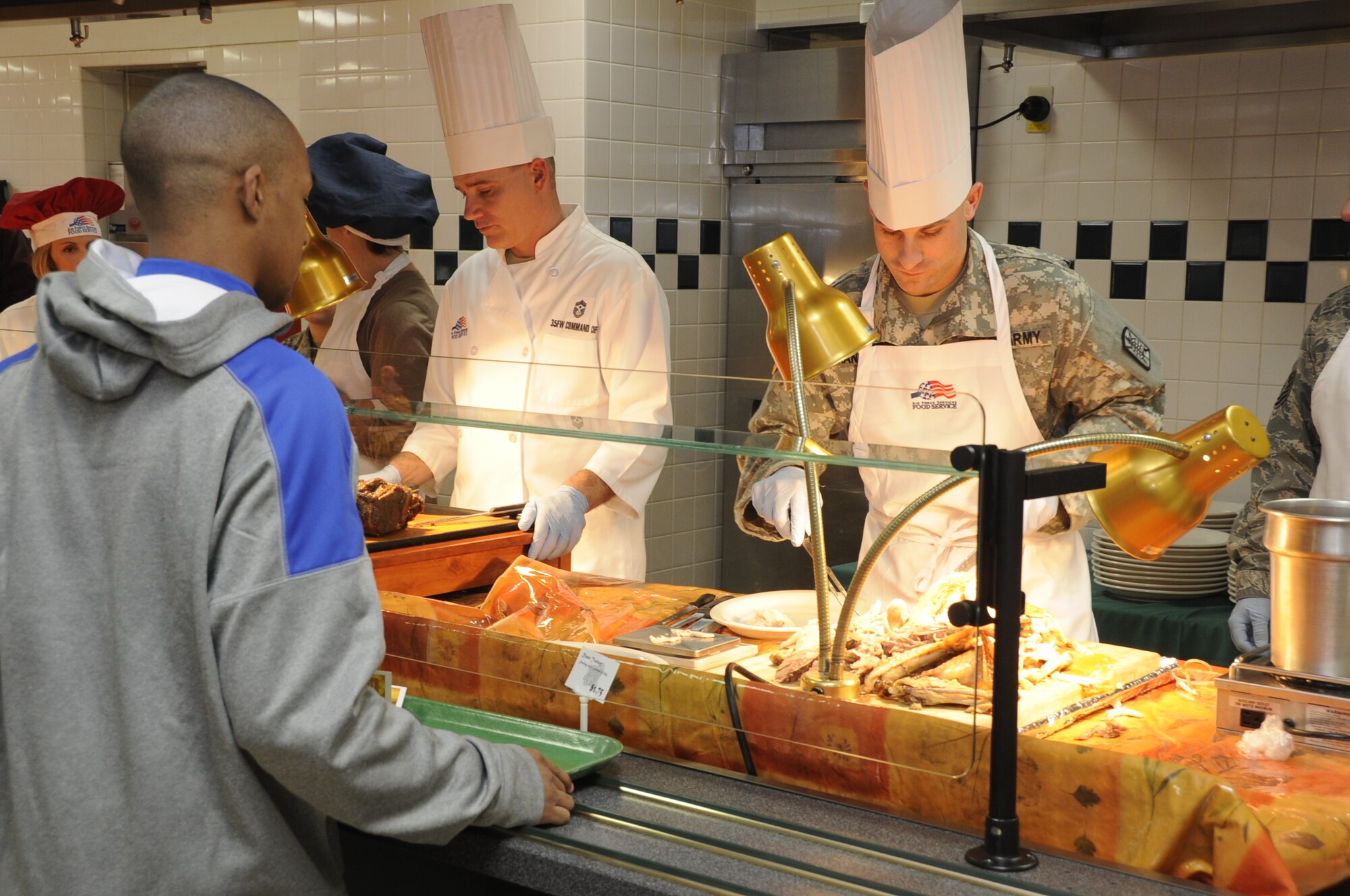 U.S. Army Chief Warrant Officer Ryan Manninen, 708th Military Intelligence Detatchment executive officer, slices turkey for a Thanksgiving meal customer in the Grissom Dining Facility at Misawa Air Base, Japan, Nov. 22, 2012. The annual meal is meant to show thanks to all unaccompanied service members for their hard work. (U.S. Air Force photo by Airman 1st Class Kaleb Snay)