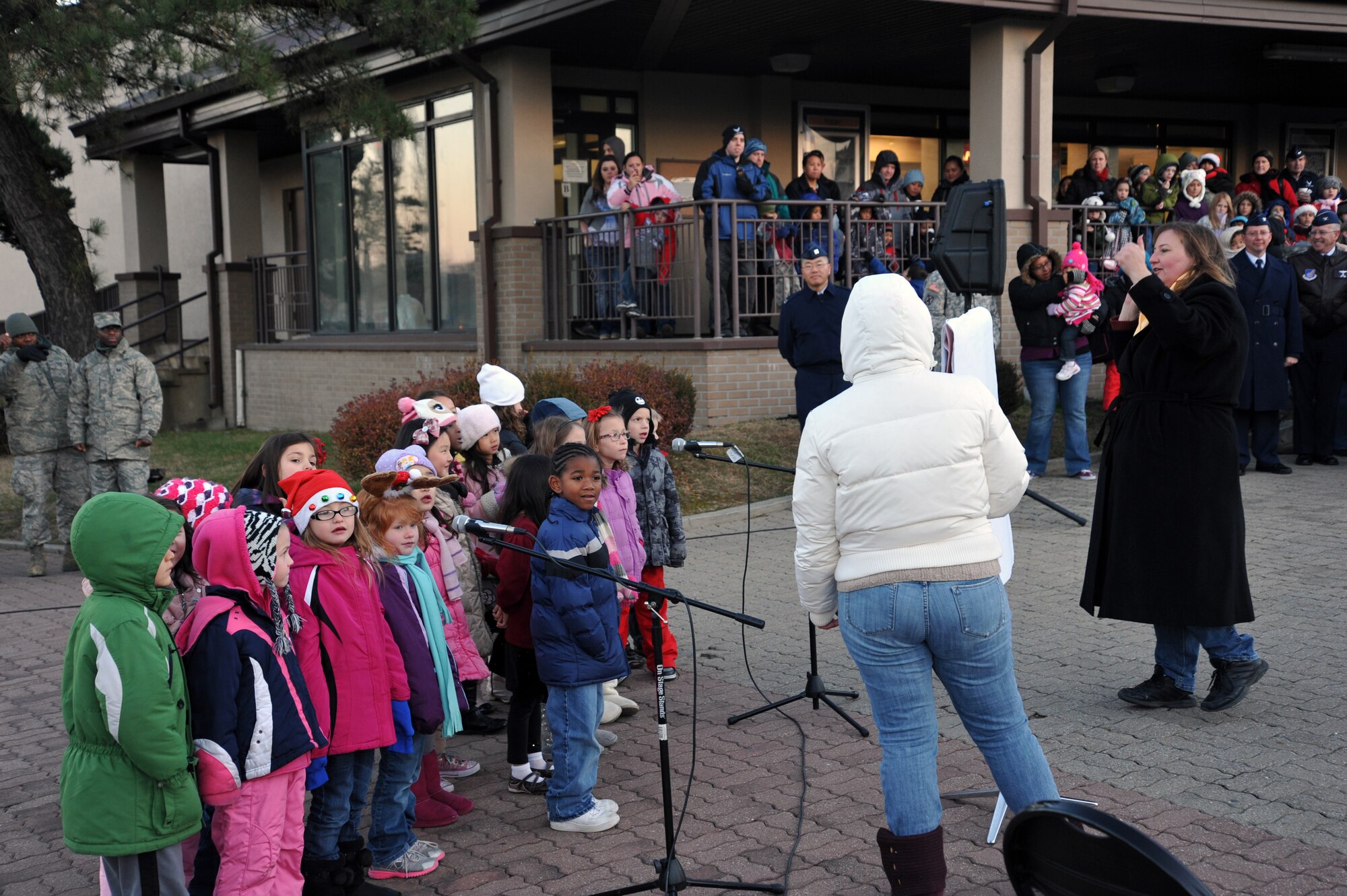 First graders from the Osan American Elementary School sing Christmas songs during the base holiday tree lighting ceremony at Osan Air Base, Republic of Korea, Nov. 26, 2012. This year’s event took place in front of the base theater with a tree constructed by the 51st Civil Engineer Squadron. (U.S. Air Force photo/Staff Sgt. Craig Cisek)
