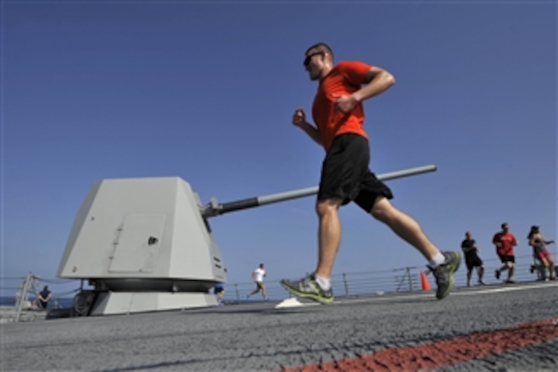 U.S. Navy Chief Warrant Officer Dane Beichter runs past the forward gun mount of the guided-missile destroyer USS Jason Dunham (DDG 109) during a Turkey Trot 5K run as the ship operates in the Arabian Sea on Nov. 22, 2012.  The Dunham is deployed to the 5th Fleet area of responsibility to conduct maritime security operations and theater security cooperation efforts.  