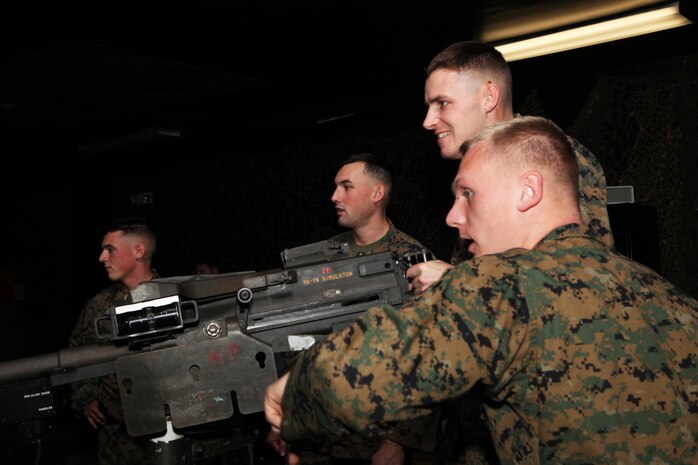 Two Marines select and engage targets with the Mark 19 grenade launcher on the Indoor Simulated Marksmanship Trainer at the Battle Skills Training School aboard Camp Lejeune, N.C., Nov. 26, 2012. The servicemembers organized their own fields of fire and operated machine guns and grenade launchers designed to mimic the weapons they will use on their upcoming deployment.