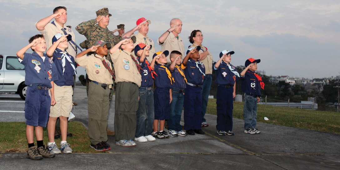 Boy Scouts, Cub Scouts, parents and volunteers salute the flag during a recent evening colors ceremony at building 1 on Camp Foster. The boys attended the ceremony to learn the history of the American flag and the significance of evening colors. The class is a part of the Boy Scouts' progression from Wolf Cubs to Bear Cubs. 