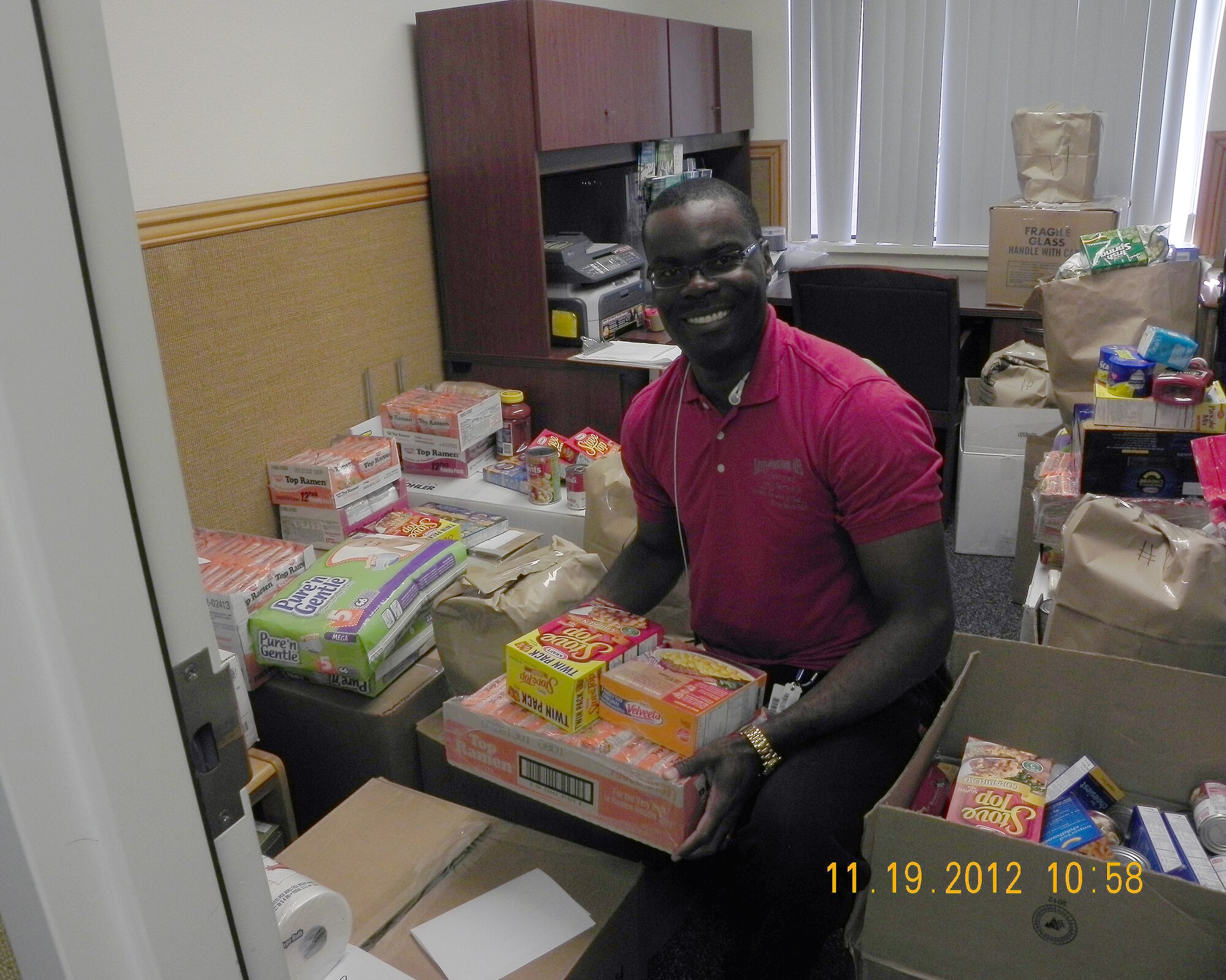 U.S. Air Force Capt. (Chaplain) Aleck Brown, 355th Fighter Wing, packs boxes of canned goods for Airmen and families in need during the Thanksgiving holiday. Volunteers collected approximately 5,000 pounds of canned goods. (Courtesy photo) 