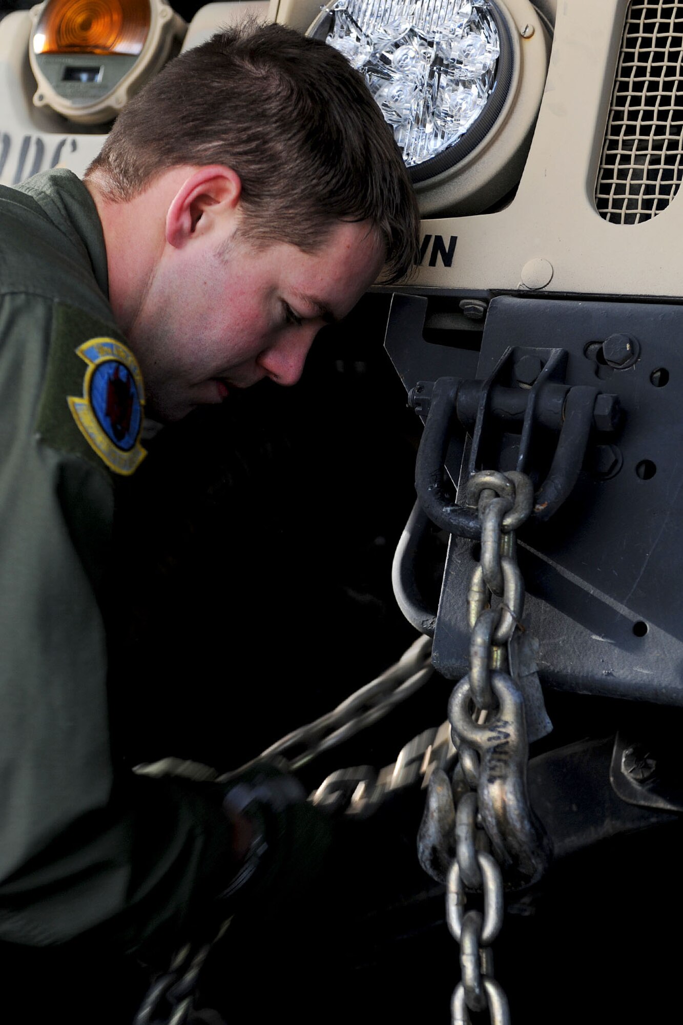 U.S. Air Force Airman 1st Class Chad Barnette, 52nd Airlift Squadron C-130 load master, ties down a Humvee during a U.S. Transportation Command Joint Task Force - Port Opening exercise at Langley Air Force Base, Va., Nov. 28, 2012. Personnel with the 52nd AS and the 689th Rapid Port Opening Element traveled to Scott Air Force Base, Ill. for a simulated-humanitarian relief assessment. (U.S. Air Force photo by Staff Sgt. Ashley Hawkins/Released)