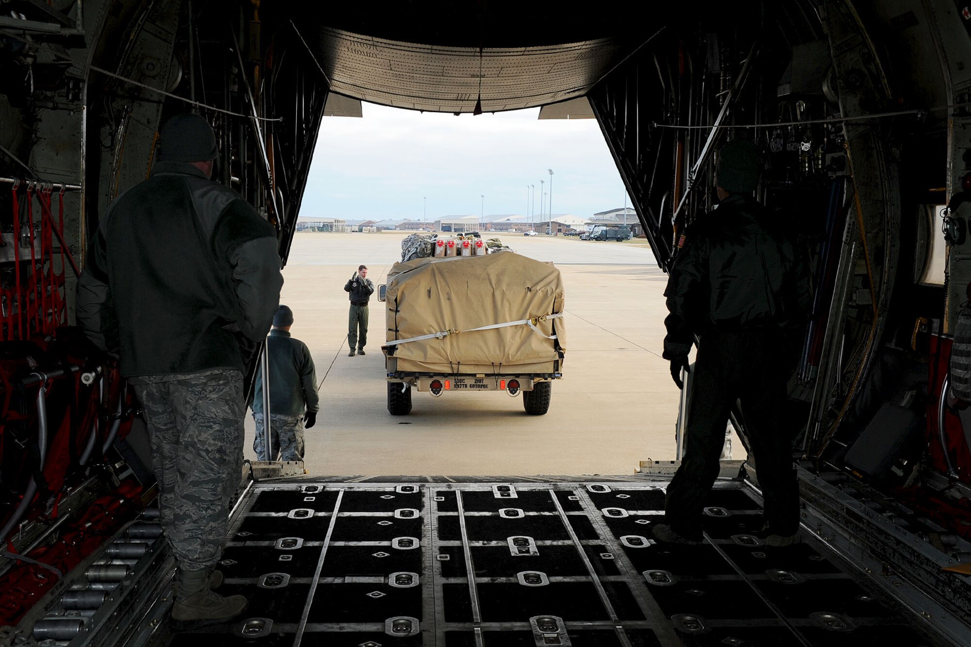 Personnel assigned to the 52nd Airlift Squadron and the 689th Rapid Port Opening Element work together to load a Humvee onto a C-130 during a U.S. Transportation Command Joint Task Force - Port Opening exercise at Langley Air Force Base, Va., Nov. 28, 2012. This is the first time TRANSCOM has conducted a full assessment of an airlift mission to support a simulated disaster or national emergency. (U.S. Air Force photo by Staff Sgt. Ashley Hawkins/Released)