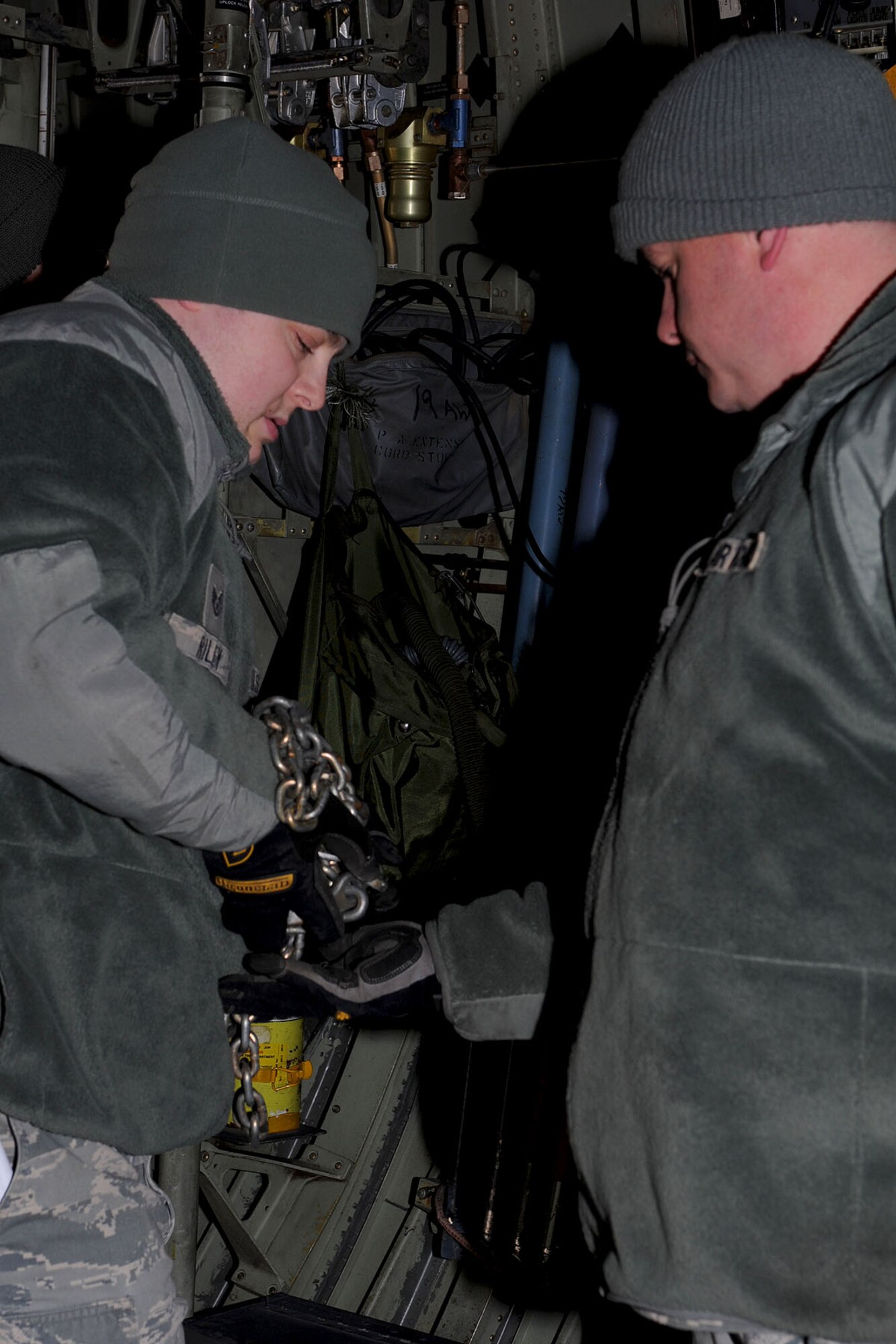 U.S. Air Force Staff Sgt. Travis Riley (left) 633rd Logistics Readiness Squadron air transportation craftsmen, hands tie-down chains to Staff Sgt. Matthew Marsh during a U.S. Transportation Command Joint Task Force - Port Opening exercise at Langley Air Force Base, Va., Nov. 28, 2012. Soldiers and Airmen worked together in a joint mission to support the assessment of an airport opening at an alternate location for a simulated-national disaster. (U.S. Air Force photo by Staff Sgt. Ashley Hawkins/Released)