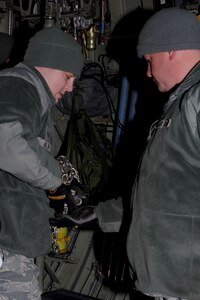 U.S. Air Force Staff Sgt. Travis Riley (left) 633rd Logistics Readiness Squadron air transportation craftsmen, hands tie-down chains to Staff Sgt. Matthew Marsh during a U.S. Transportation Command Joint Task Force - Port Opening exercise at Langley Air Force Base, Va., Nov. 28, 2012. Soldiers and Airmen worked together in a joint mission to support the assessment of an airport opening at an alternate location for a simulated-national disaster. (U.S. Air Force photo by Staff Sgt. Ashley Hawkins/Released)