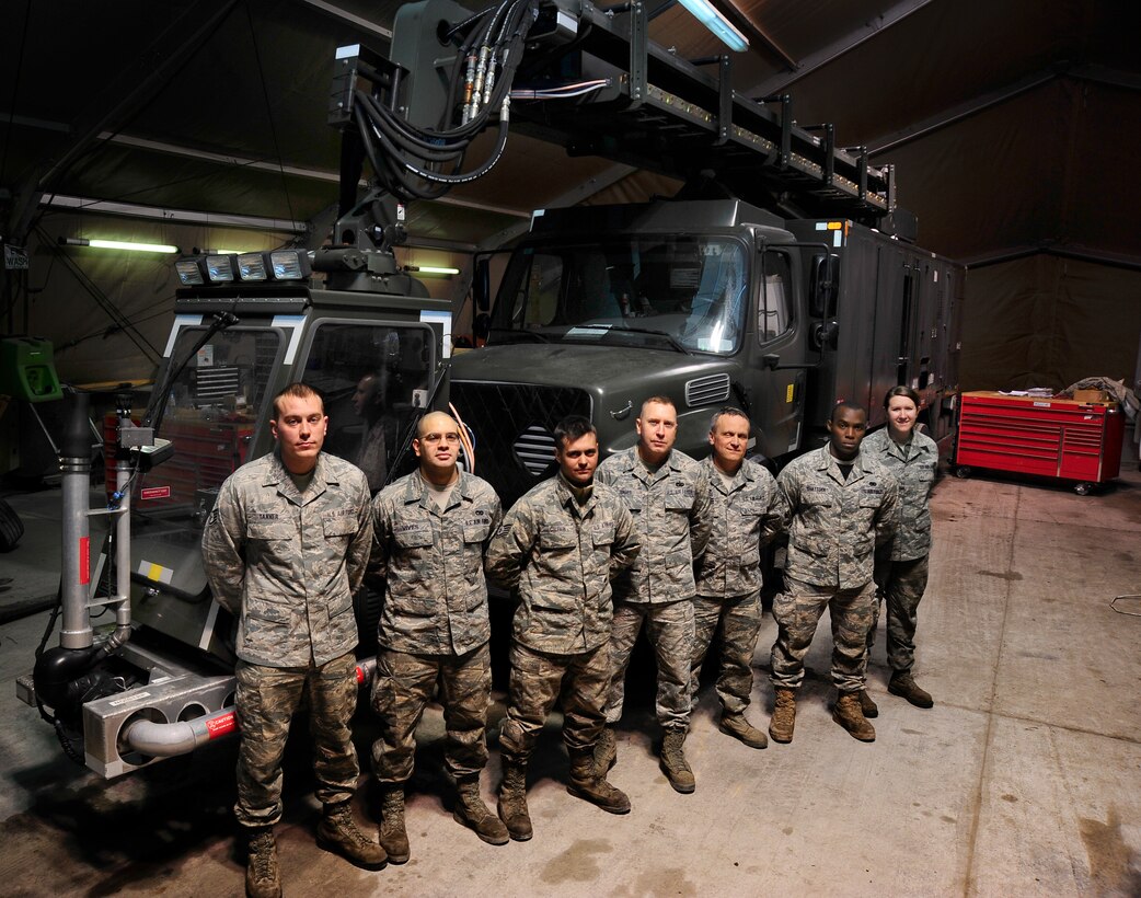 Staff Sgt. Anthony Tanner from the 117th Air Refueling Wing along with other Airmen deployed from various locations stand at parade rest in front of a standard deicer truck Dec. 10, 2011 in the vehicle maintenance special purpose shop at the Transit Center at Manas, Kyrgyzstan. These seven Airmen from the 376th Expeditionary Logistics Readiness Squadron replaced a standard deicer truck’s heater canister in seven hours. (U.S. Air Force photo/Staff Sgt. Angela Ruiz)