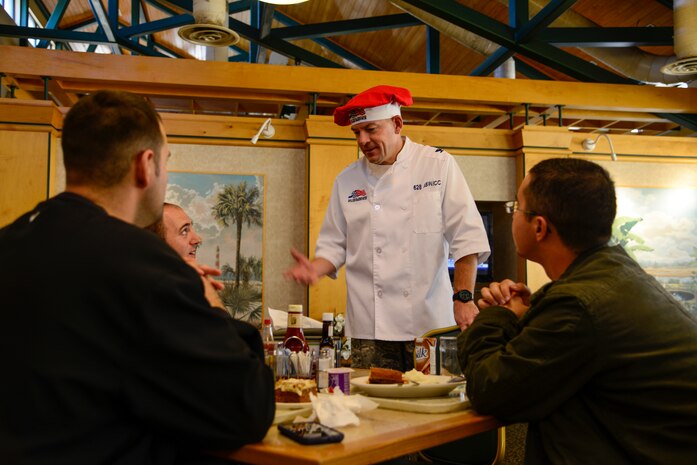 Colonel Richard McComb, 628th Air Base Wing commander, talks to Airmen at the Robert D. Gaylor dining facility after serving Thanksgiving dinner Nov. 24, 2012, at Joint Base Charleston - Air Base, S.C. McComb, along with other unit commanders, chiefs and their families, took time to serve Thanksgiving dinner to their fellow Airmen and retirees. (U.S. Air Force photo/Staff Sgt. Rasheen Douglas)