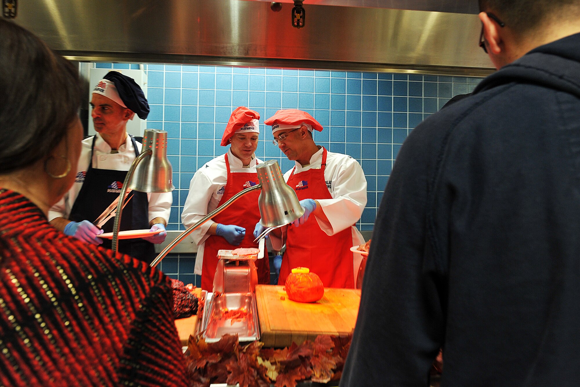 U.S. Air Force Col. John Rauch, 55th Wing commander, observes U.S. Air Force Col. Hans Palaoro, 55th Wing vice commander, weighing ham on a scale during Thanksgiving lunch at the Ronald L. King Dining Facility on Offutt Air Force Base, Neb., Nov. 22. It has become customary for base leadership to show their thanks to the Airman by serving lunch on Thanksgiving. (U.S. Air Force photo by Charles Haymond/Released)