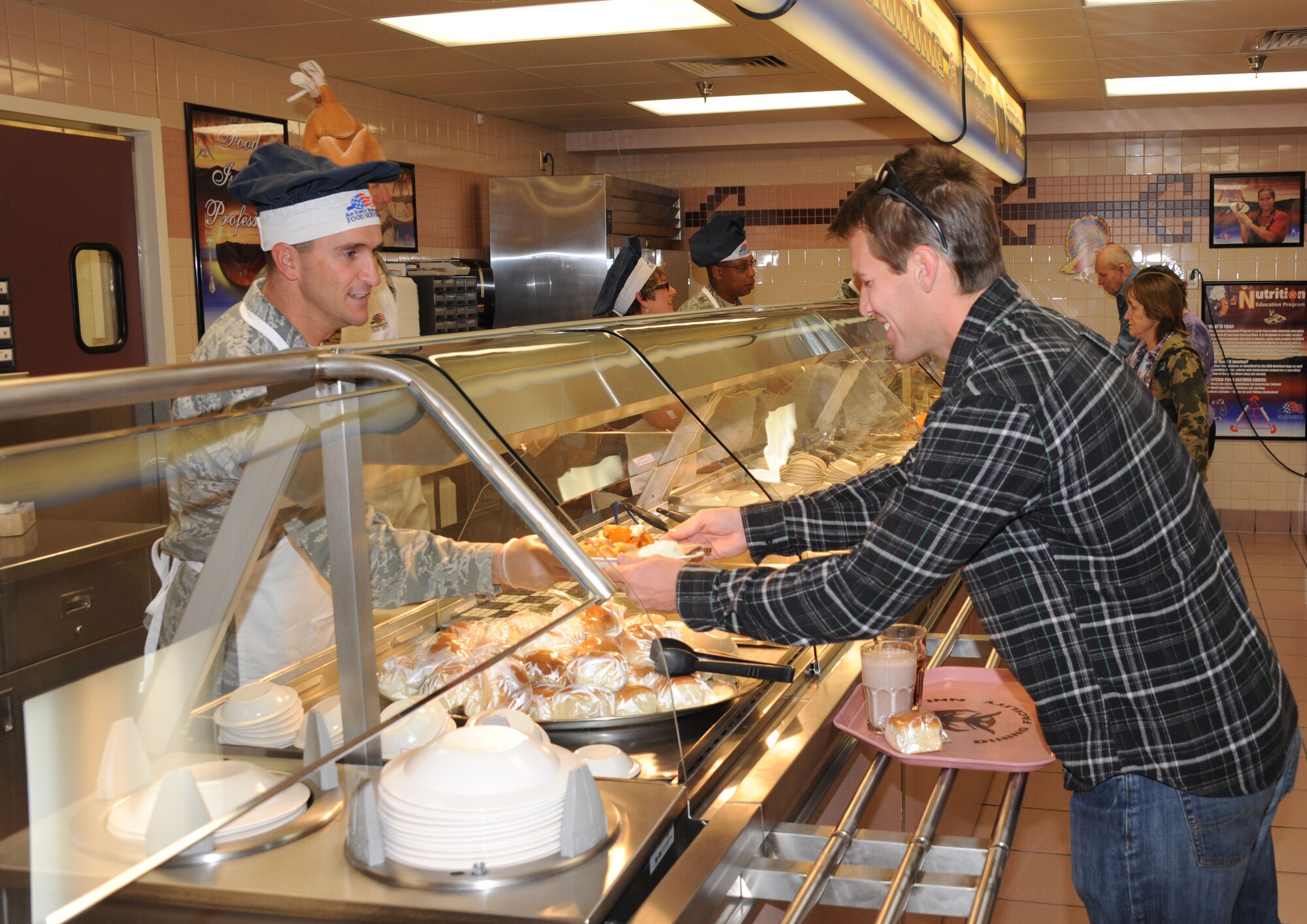 KIRTLAND AFB, N.M. -- Lt. Col. Bryan Eckart, 377th Weapons System Security Squadron commander, serves a Thanksgiving meal Nov. 22 to a patron at the Thunderbird Inn dining facility at Kirtland AFB. (Photo by Dennis Carlson)