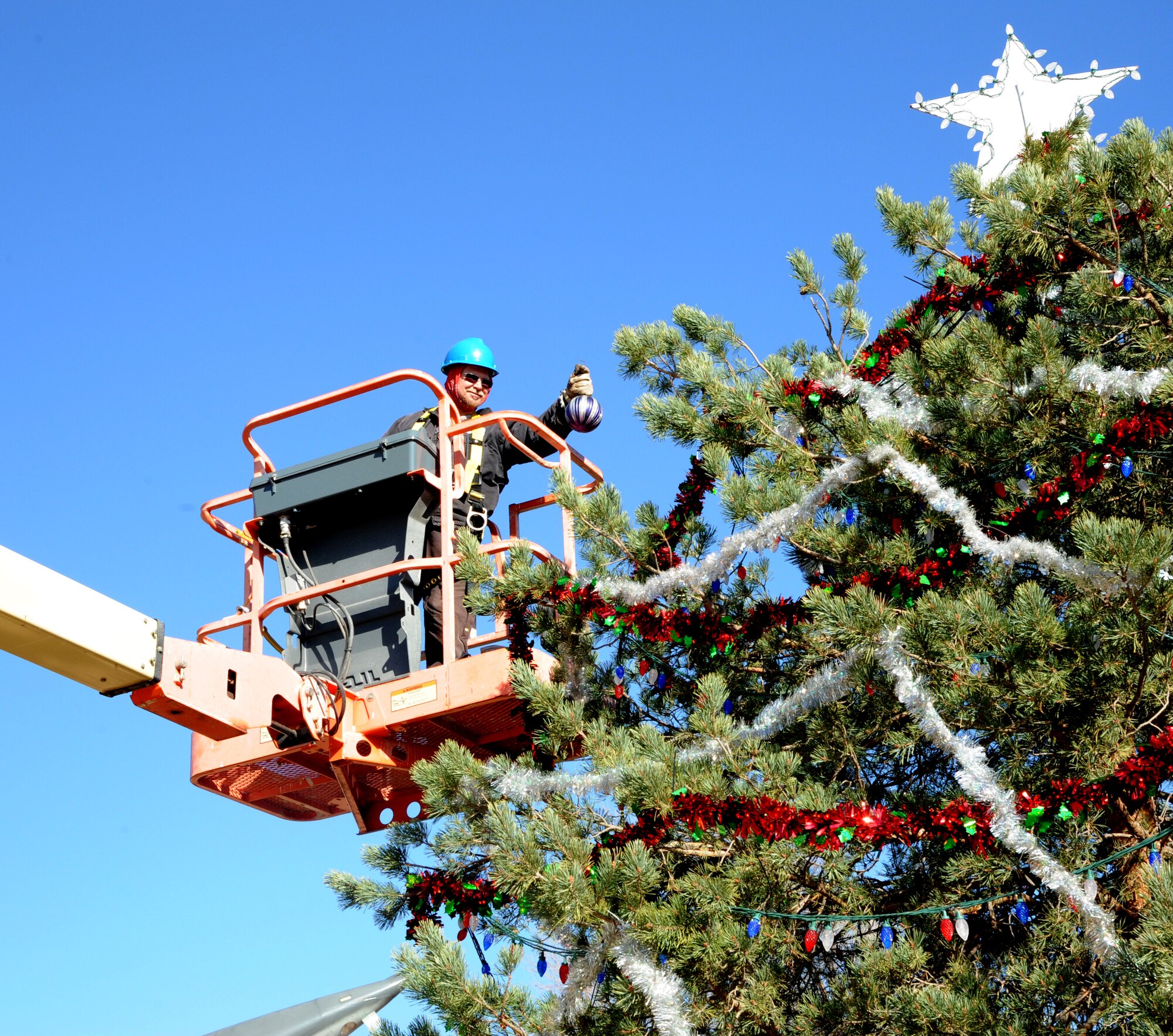 Troy McDonald with the CSC Civil Engineering Pavement and Grounds shop, hangs one of more than 50 ornaments on the Christmas Tree at Vance Air Force Base, Okla. A lighting ceremony is scheduled at 5 p.m., Dec. 5. (U.S. Air Force photo/ Airman 1st Class Frank Casciotta) 