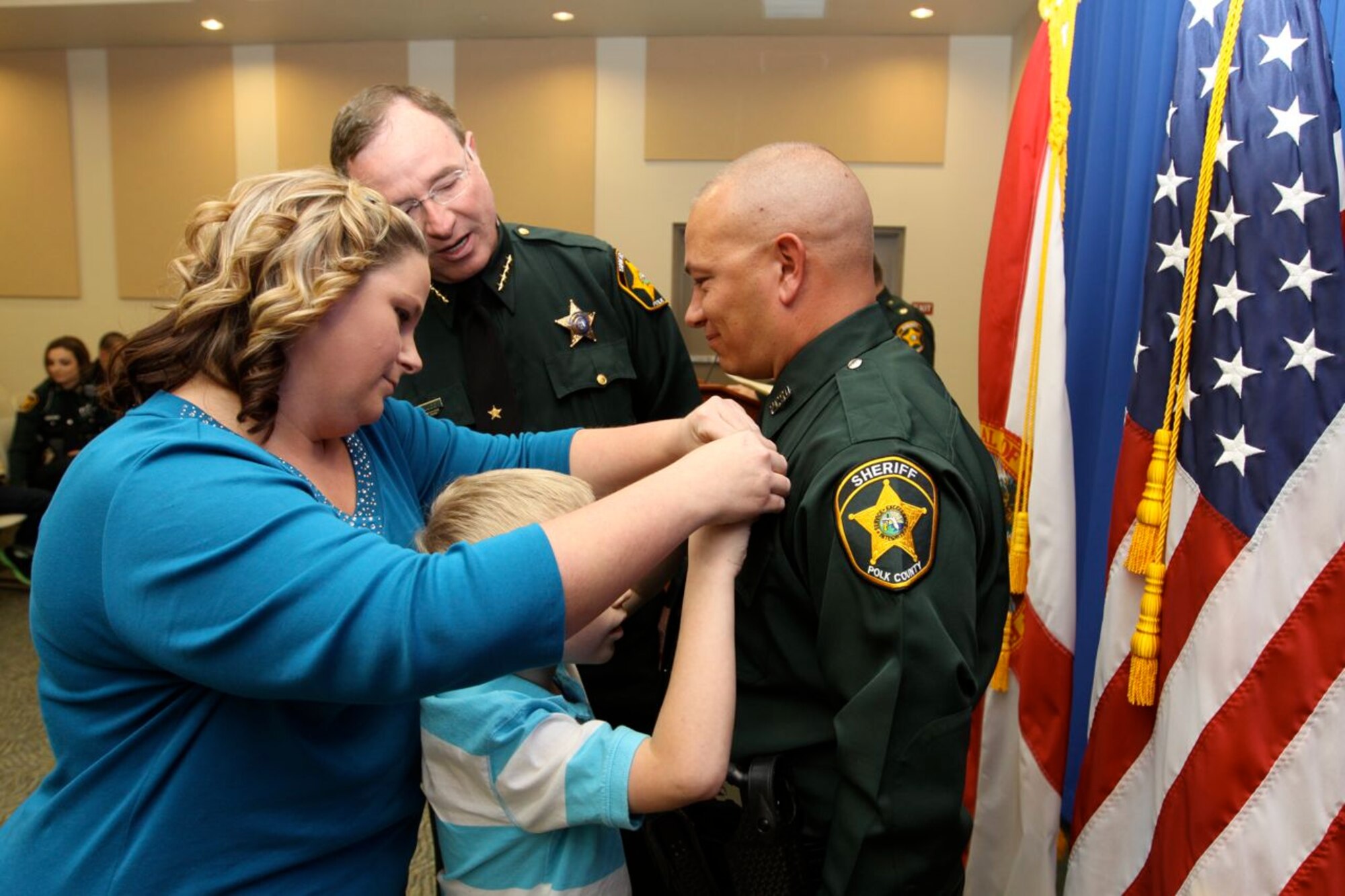 U.S. Air Force Staff Sgt. Steven Jefferson, 23d Wing Det. 1 Avon Park ground safety manager, stands as his family pins on his badge, Nov. 1, 2012. Jefferson said the 11 months of training at the South Florida State College Criminal Justice Academy was hard on him and his family but was worth it in the end. (U.S. Air Force photo by Airman 1st Class Jarrod Grammel/Released)