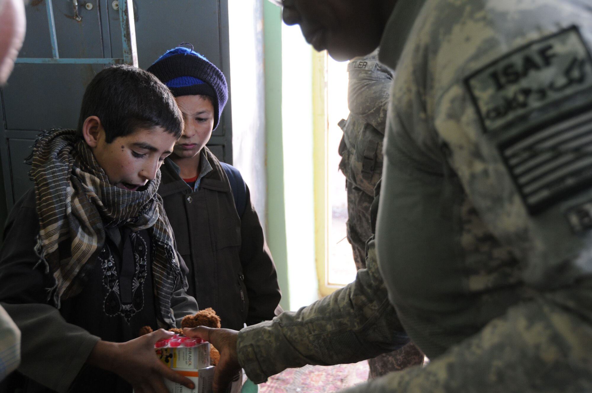 HM2 Biza Strickland, from the Naval Medical Center, Portsmouth, Va., NCOIC of the Provincial Reconstruction Team Ghazni Clinic, hands out cough syrup and de-worming medication to a child inside the orphanage clinic in Ghazni City, Afghanistan on Dec. 16, 2009.  (U.S. Air Force/Tech Sgt. Rebecca F. Corey, PRT Ghazni)