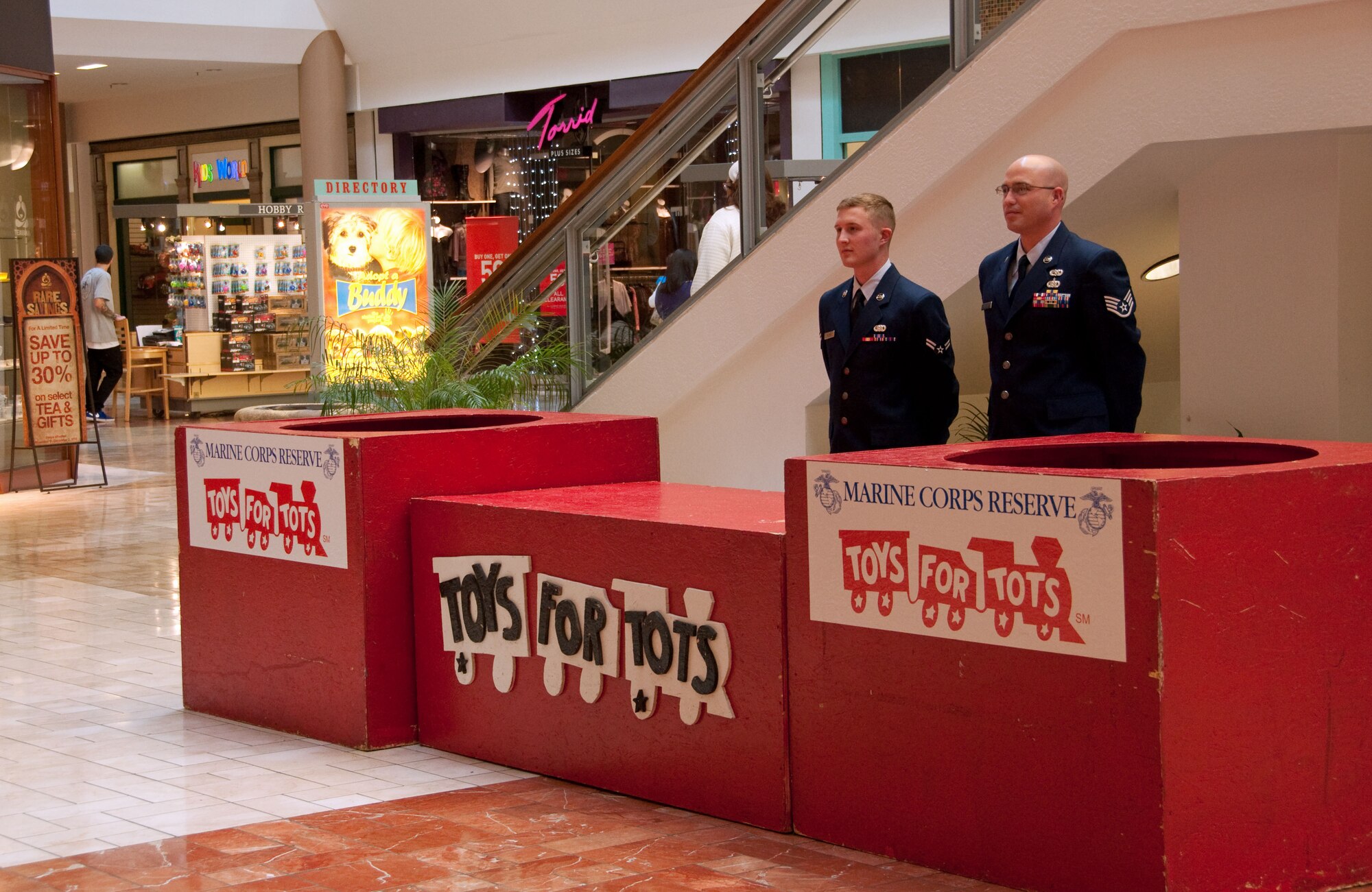 Staff Sgt. Daniel Nelson and Airman 1st Class Travis Allred, both from the 60th Logistics Readiness Squadron, volunteer to assist  the 373rd Training Squadron, Detachment 14 Nov. 27 with the Toys for Tots program by collecting toy donations from inside Solano Mall, Fairfield, Calif. (U.S. Air Force photo/Airman 1st Class Madelyn Brown).