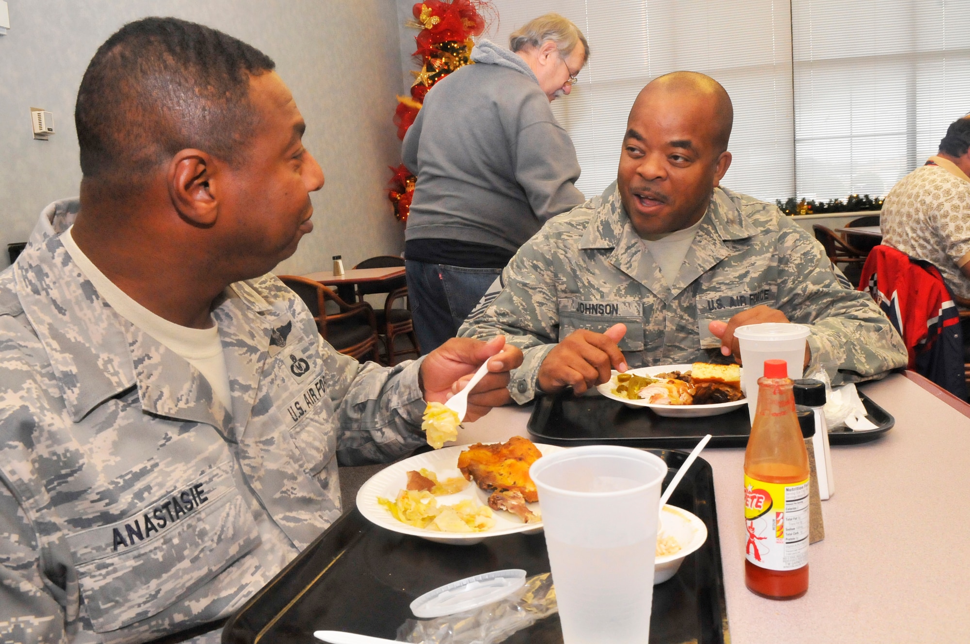 L-R, Chief Master Sgt. Lorenzo Anastasie, 116th Air Control Wing Command Chief, and Master Sgt. Jonathan Johnson, 116th ACW, enjoy a meal at "The Quick Turn", formerly known as the Flight line dining facility.   (U. S. Air Force photo/Sue Sapp)