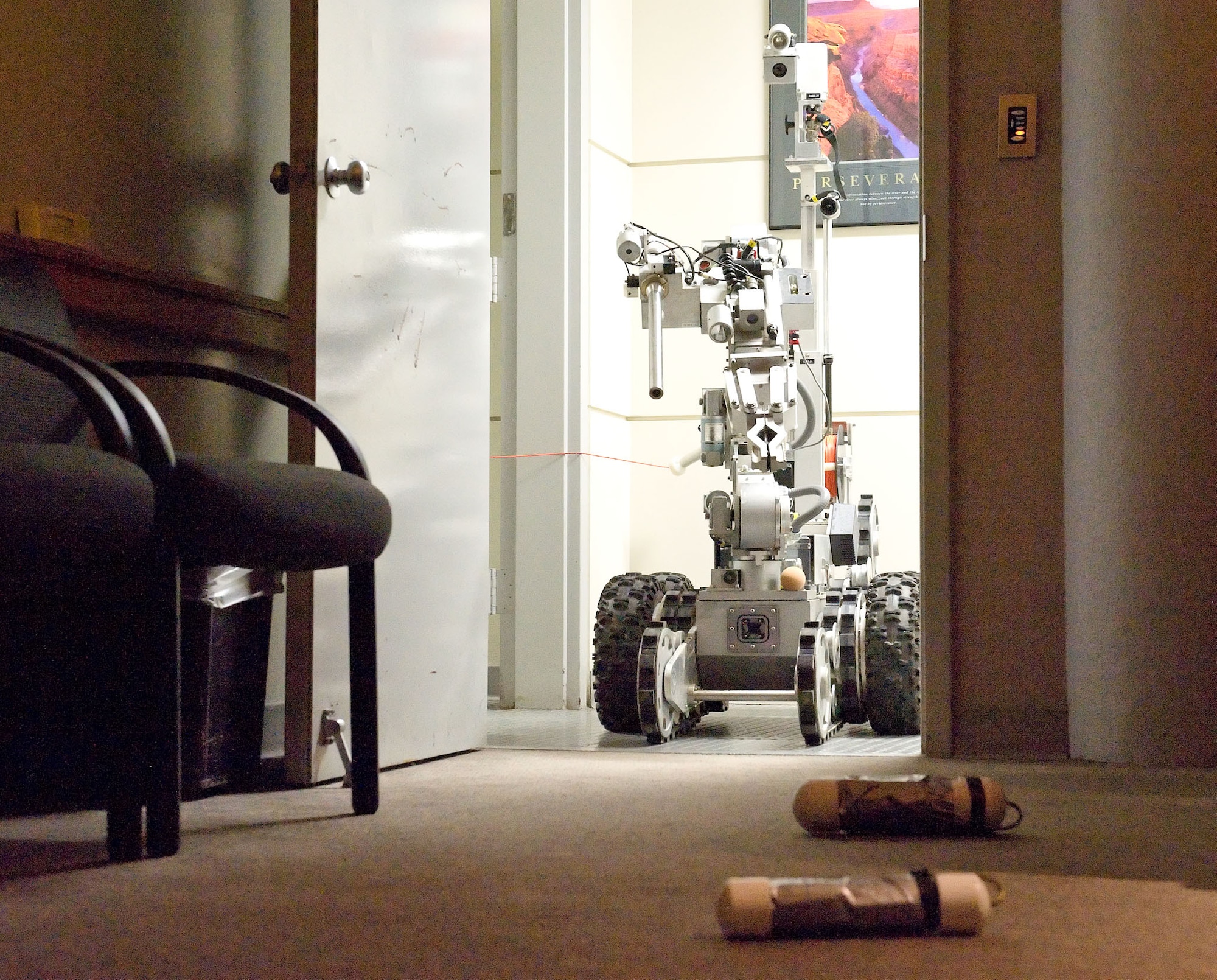 An Explosive Ordinance Disposal robot remotely inspects two simulated suspicious objects in building 600 Nov. 15, 2012, at Dover Air Force Base, Del. From a quarter-mile away, EOD personnel controlled the robot during the Major Accident Response Exercise, held to test Team Dover's ability to respond to simulated incidents on base. (U.S. Air Force photo by Roland Balik)