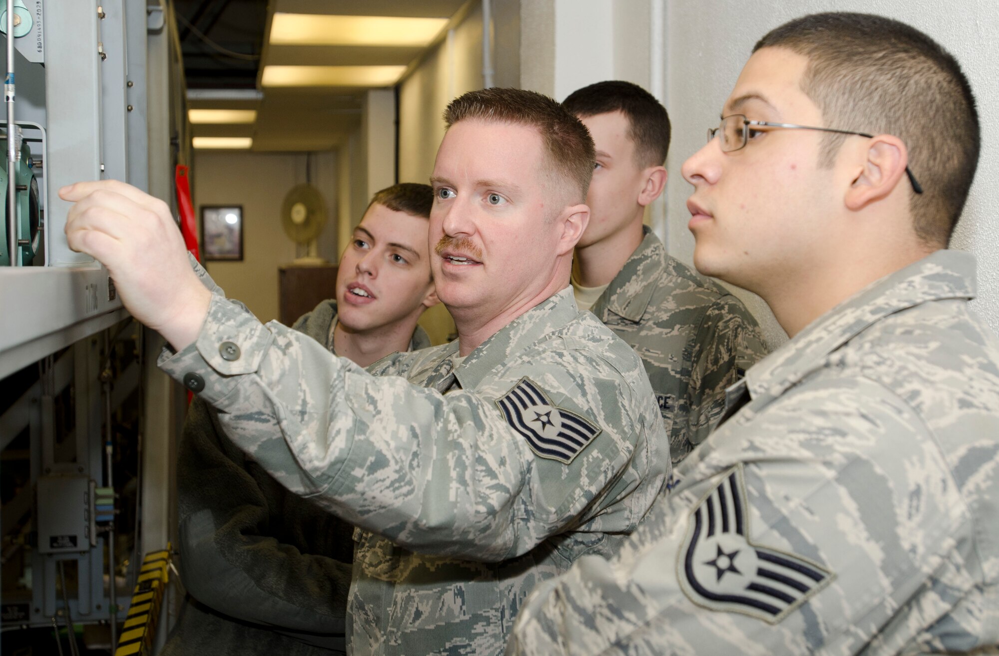 ROYAL AIR FORCE LAKENHEATH, England - Tech. Sgt. Scott Douglass (center), 372nd Training Squadron, Detachment 16 tactical aircraft maintenance instructor and native of Dayton, Ohio, briefs students on the different capabilities of a landing gear trainer during an F-15 hydraulics course Nov. 27, 2012. The trainer replaces the need to use an actual aircraft while reducing man-hours associated with the course and providing students with a better training environment. (U.S. Air Force photo by Staff Sgt. Stephen Linch)