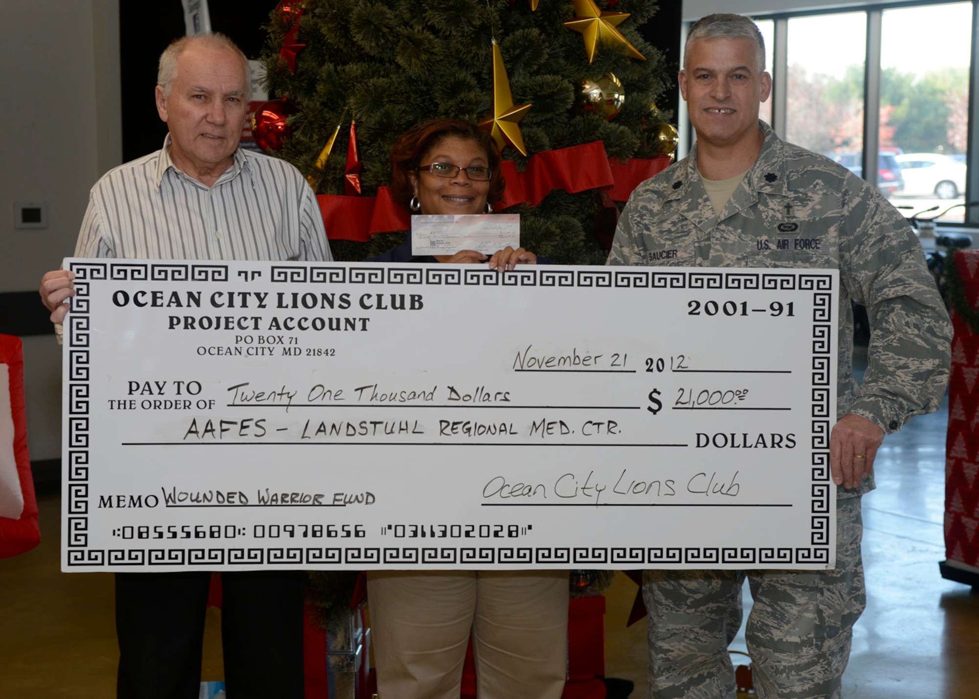 Ben Dawson, co-chair of the Ocean City, Md., Lions Club, presents a check of $21,000 to Yvette Russel, computer manager of the Base Exchange, and Chaplain (Lt. Col.) Dennis Saucier, 436th Airlift Wing chaplain Nov. 21, 2012, at the Base Exchange on Dover Air Force Base, Del. The $21,000 will go to help wounded warriors at Landstuhl Regional Medical Center, Germany. The Ocean City, Md., Lions Club has raised $200,000 for wounded warriors since 2004. (U.S. Air Force photo by Tech. Sgt. Chuck Walker)