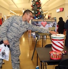 Senior Airman Isaias De Leon, 902nd Security Forces Squadron, donates money to Operation Warmheart Nov. 27 at the Joint Base San Antonio-Randolph Exchange. Operation Warmheart supplies food to service members in difficult financial situations during the holiday season. (U.S. Air Force photo by Rich McFadden) 