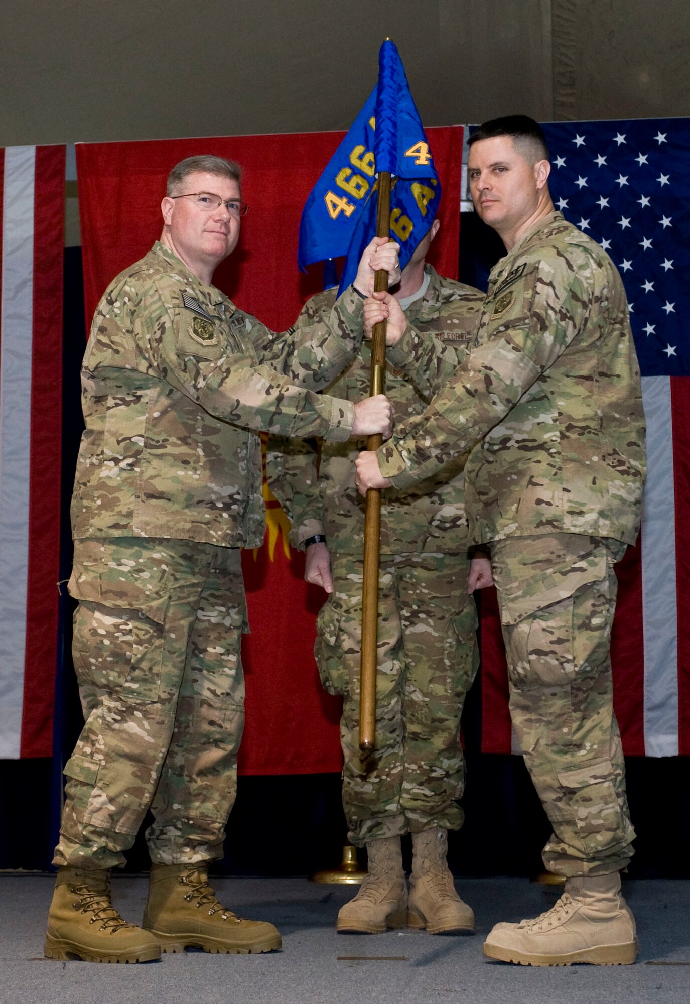 Col. John Cline, left, 466th Air Expeditionary Group commander passes the newly activated 466th Air Expeditionary Squadron guidon to Lt. Col. Joshua Hetsko, incoming commander, during an activation and asssumption of command ceremony, Transit Center at Manas, Kyrgyzstan, Nov. 26, 2012. Hetsko?s new squadron will assist the 466 AEG?s mission to provide administrative support and accountability for more than 2,300 Joint Expeditionary Tasking Airmen and Individual Augmentees serving throughout Afghanistan. (U.S. Air Force photo/Senior Airman Stephanie Rubi)