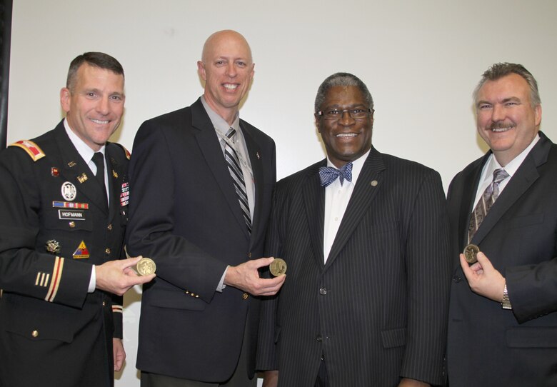 Kansas City, Mo., Mayor Sly James (second from right) presents coins to (left to right) Col. Anthony J. Hofmann and John D. Holm of the U.S. Army Corps of Engineers and John L. Robinson of SVS, Inc. on Nov. 28, 2012, as part of an awards presentation for the Blue River Project. The project won the Alphonse J. Dell'Isola Award for outstanding Value Engineering accomplishments from SAVE International. U.S. Army Corps of Engineers photo by Diana McCoy