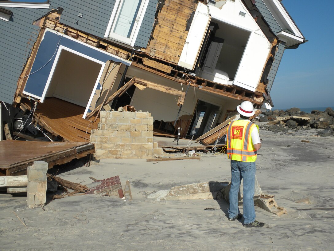 Doug Weber, infrastructure assessment action officer, U.S. Army Corps of Engineers, Seattle District, looks at building damages, Mantoloking, N.J., during an infrastructure assessment after Hurricane Sandy. The Corps of Engineers Infrastructure Assessment Planning and Response Teams (IA-PRTs) augment local efforts to inspect buildings that are primarily residential, and to manage inspections of public works facilities following a major disaster, as assigned by FEMA. The IA mission is intended to be highly flexible and scalable in order to meet the specific and changing needs of impacted communities during response and recovery efforts. 